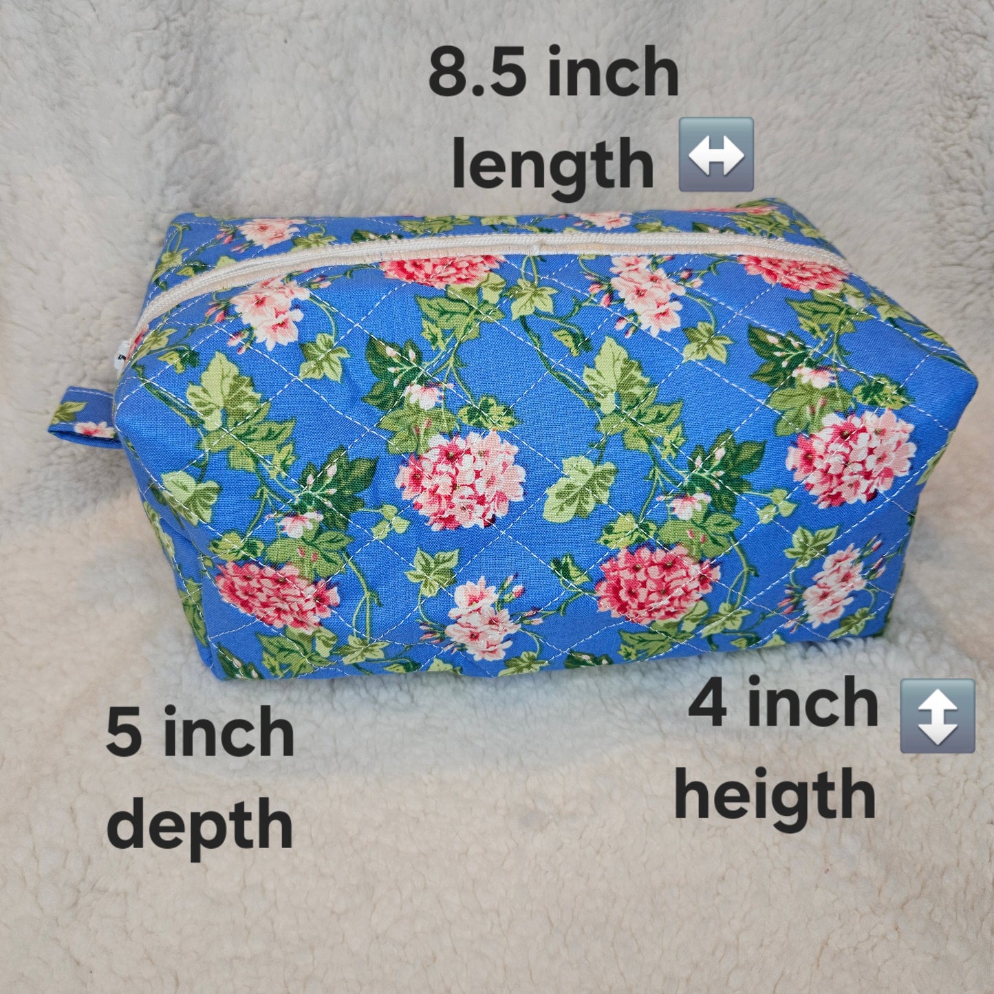 Blue floral-patterned pouch with measurements on a gray background
