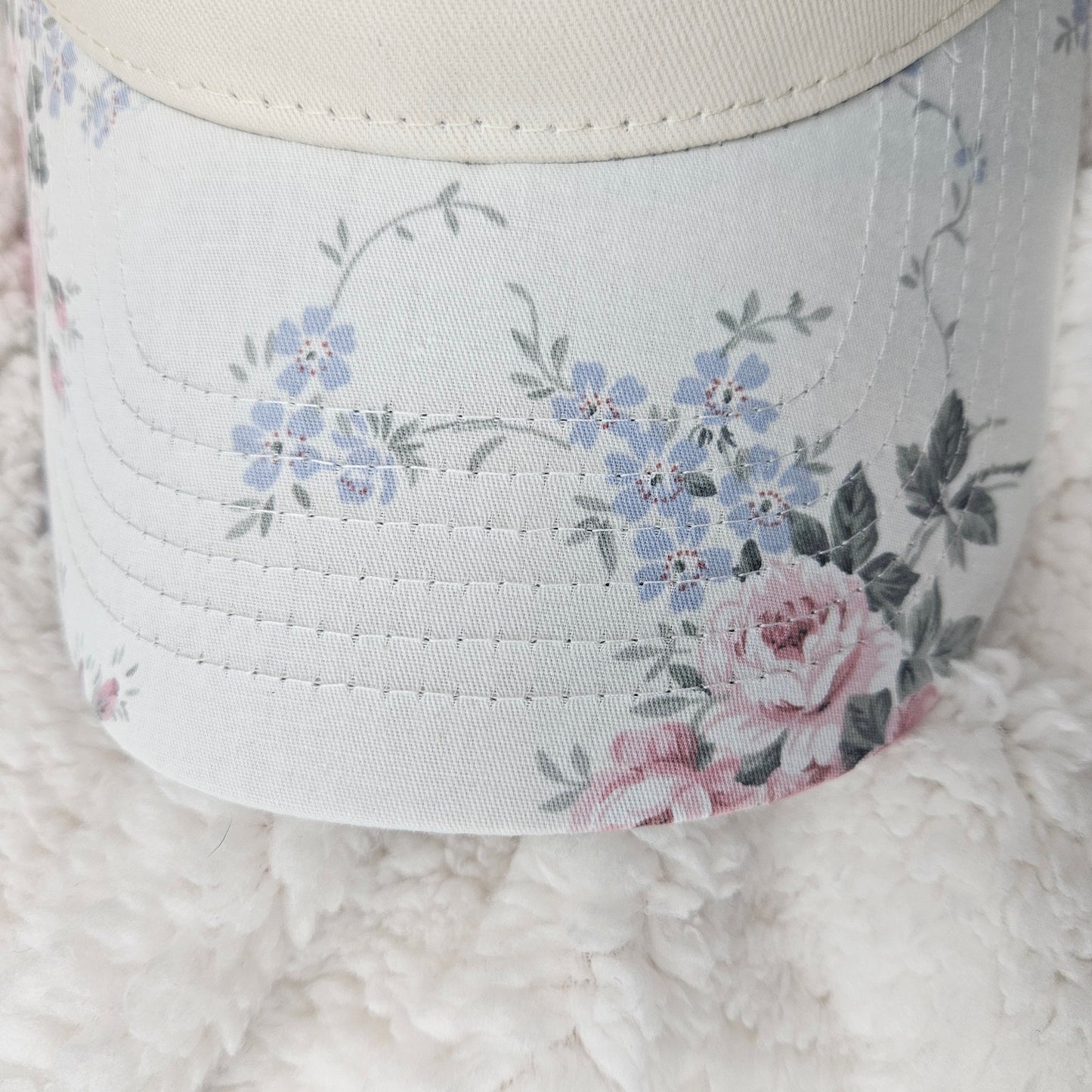 Floral design on bill of cap on a textured surface