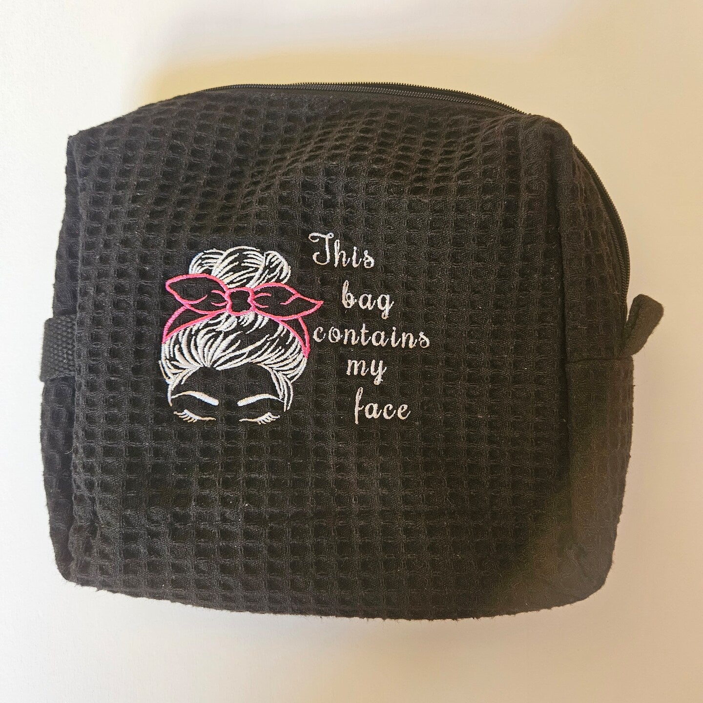 Black make up bag with This Bag design embroidered on front