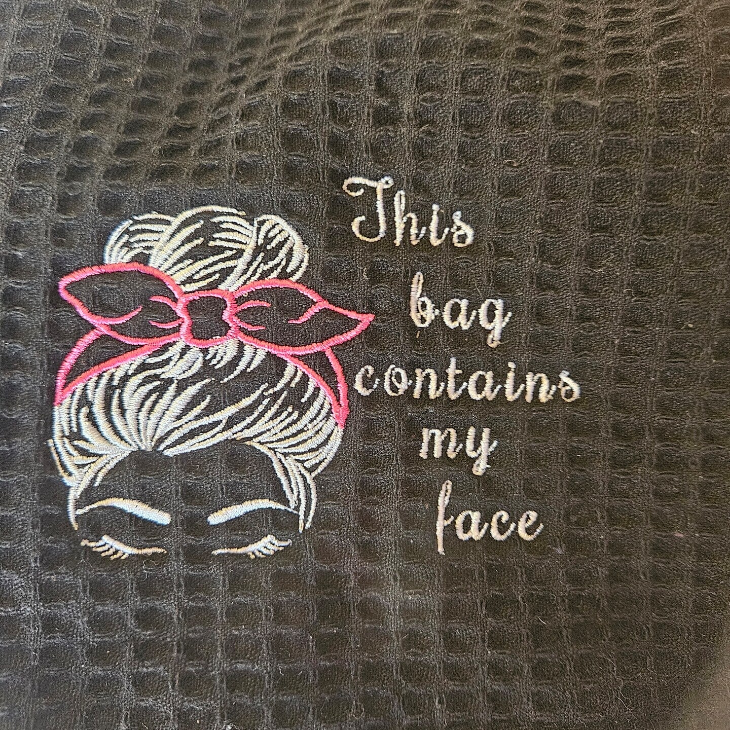 Close up of black bag with This Bag design embroidered