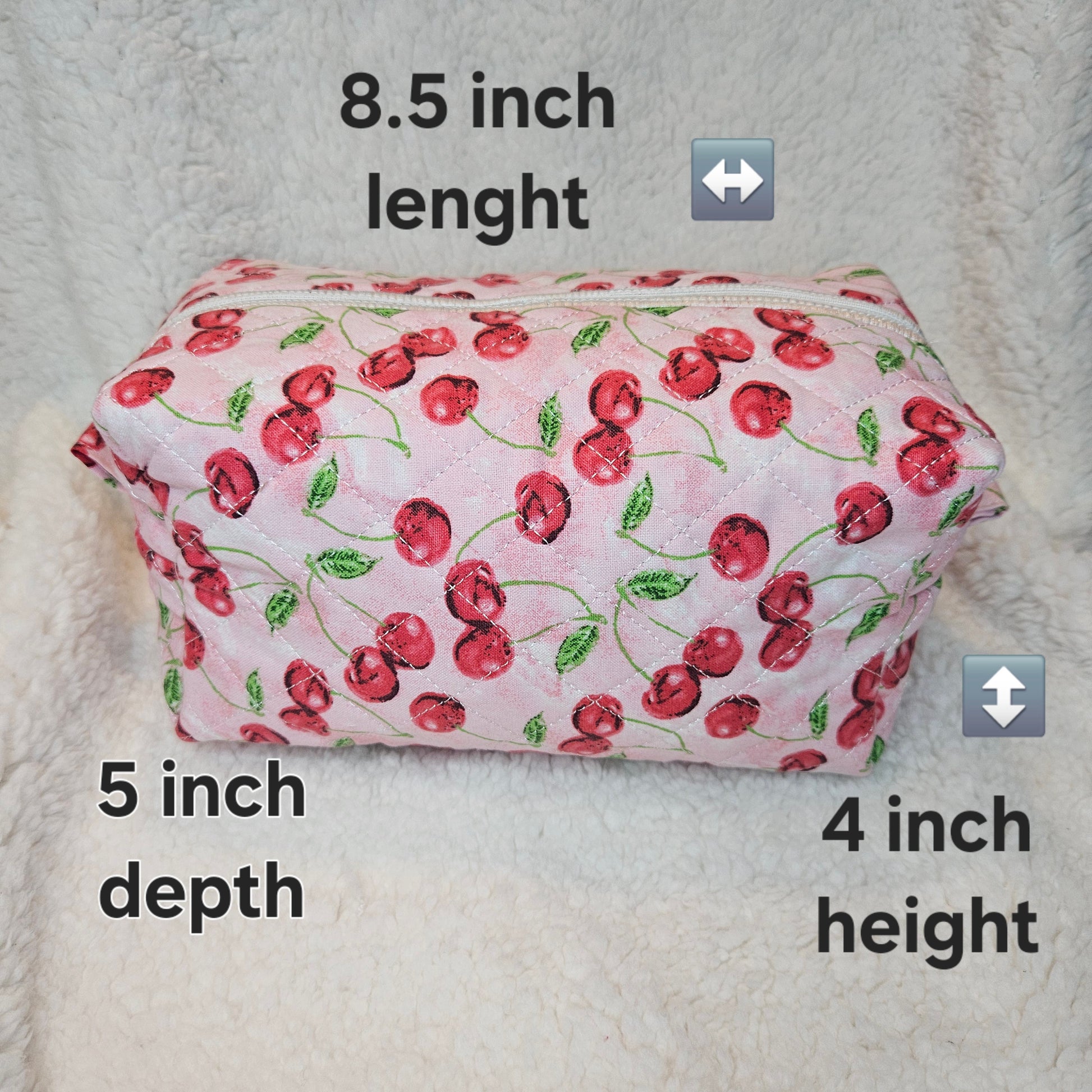 Pink pouch with cherry pattern on a textured surface, labeled with dimensions.