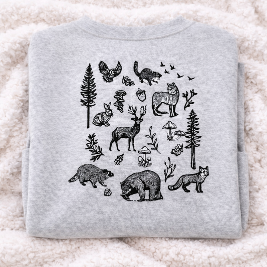 Folded ash gray sweatshirt, stitched on back with black forest animal illustrations on a light background