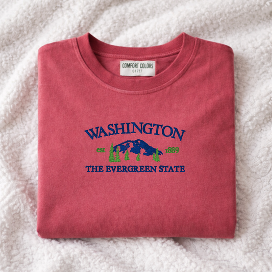 Folded crimson t-shirt with 'Washington The Evergreen State' text and design on a white background