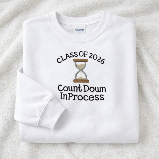 White sweatshirt with 'Class of 2026 Countdown In Process' text and sand hourglass embroidery on a white background