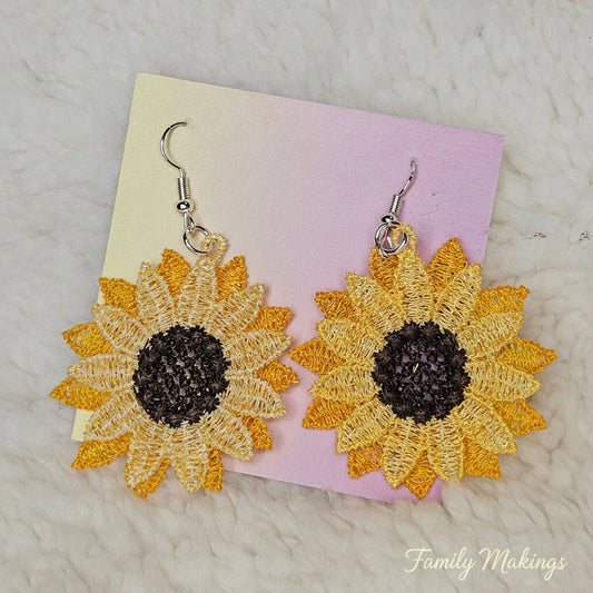 Sunflower embroidered earrings with silver posts on a card