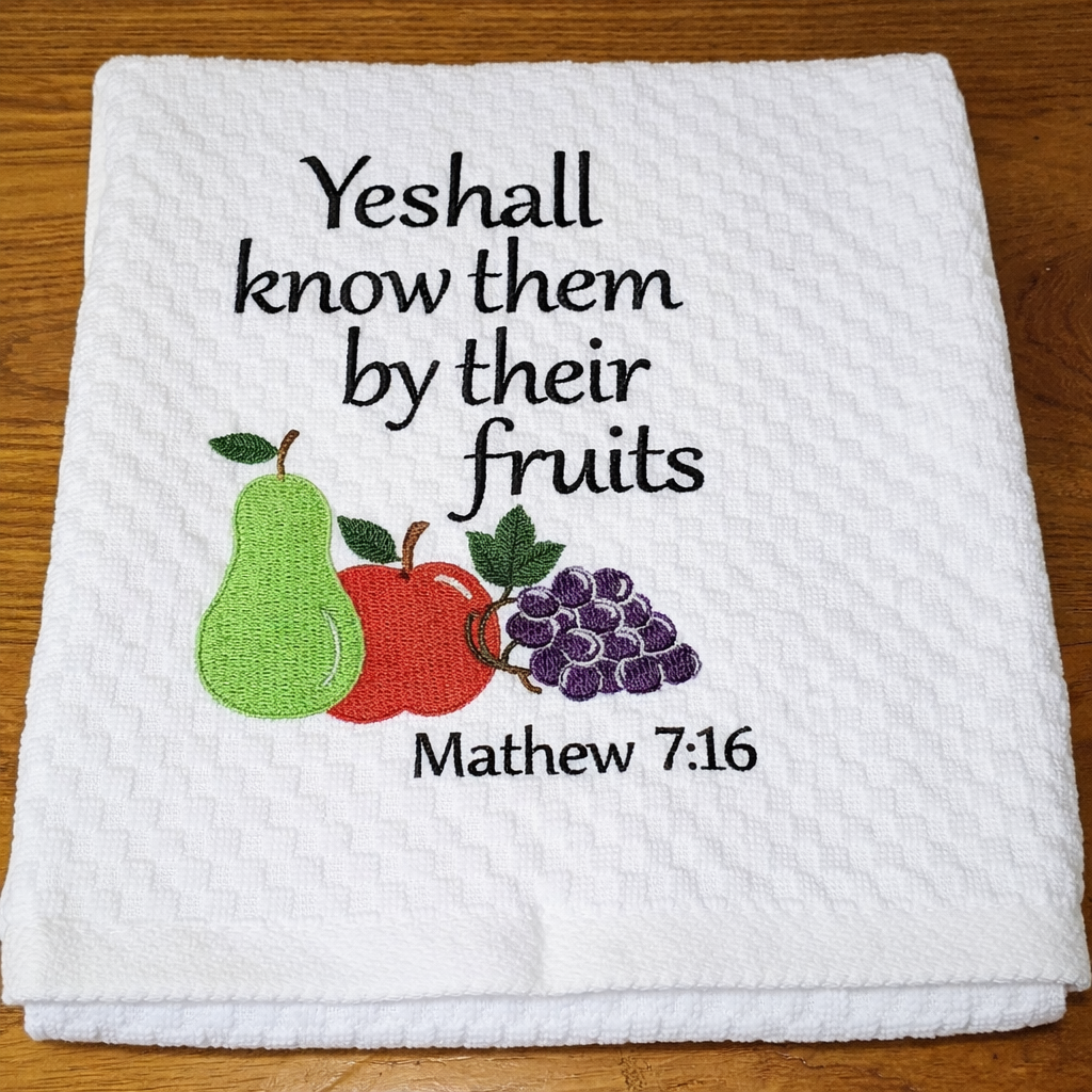 White towel with fruit illustrations and text on a wooden surface