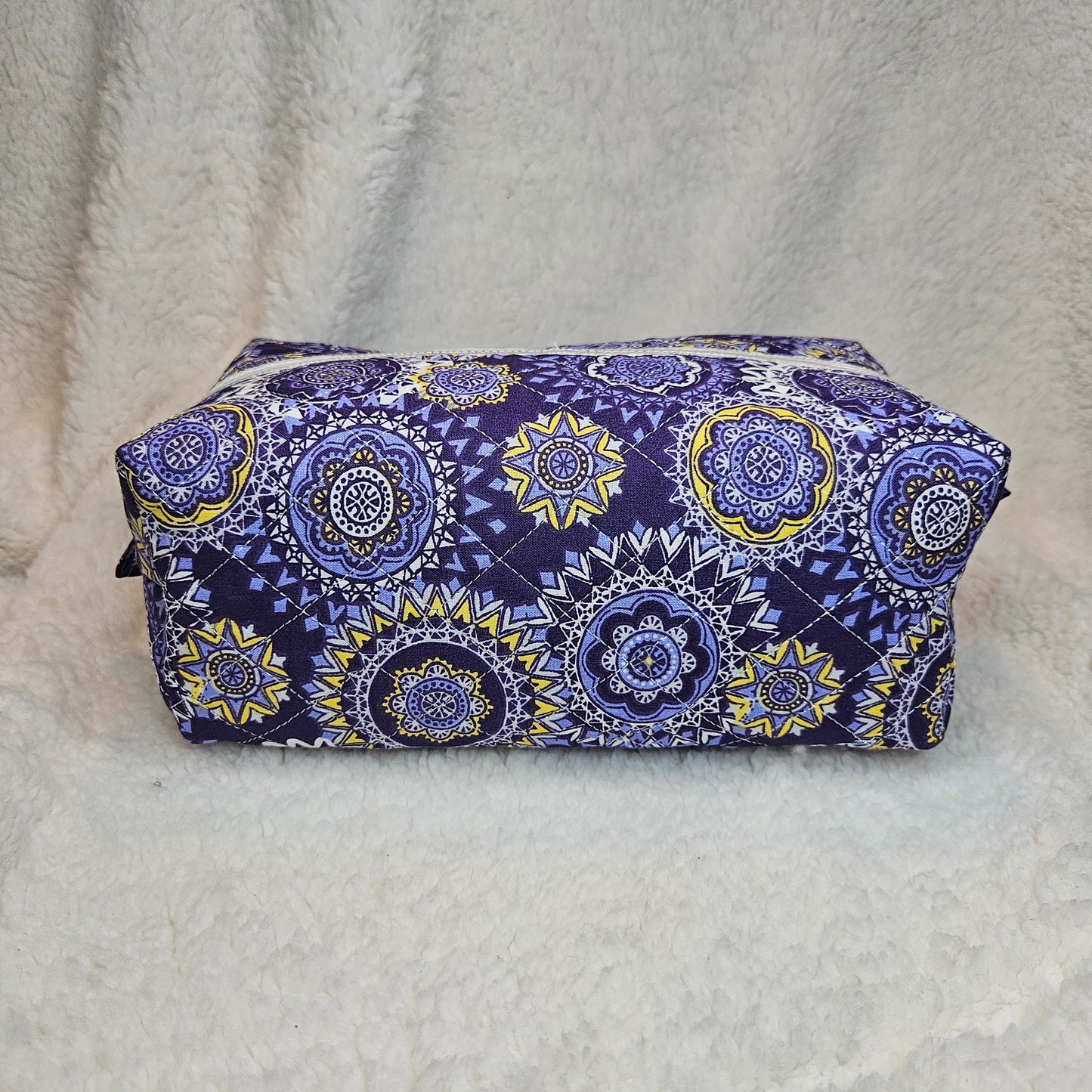 Purple and yellow patterned fabric on a white textured background