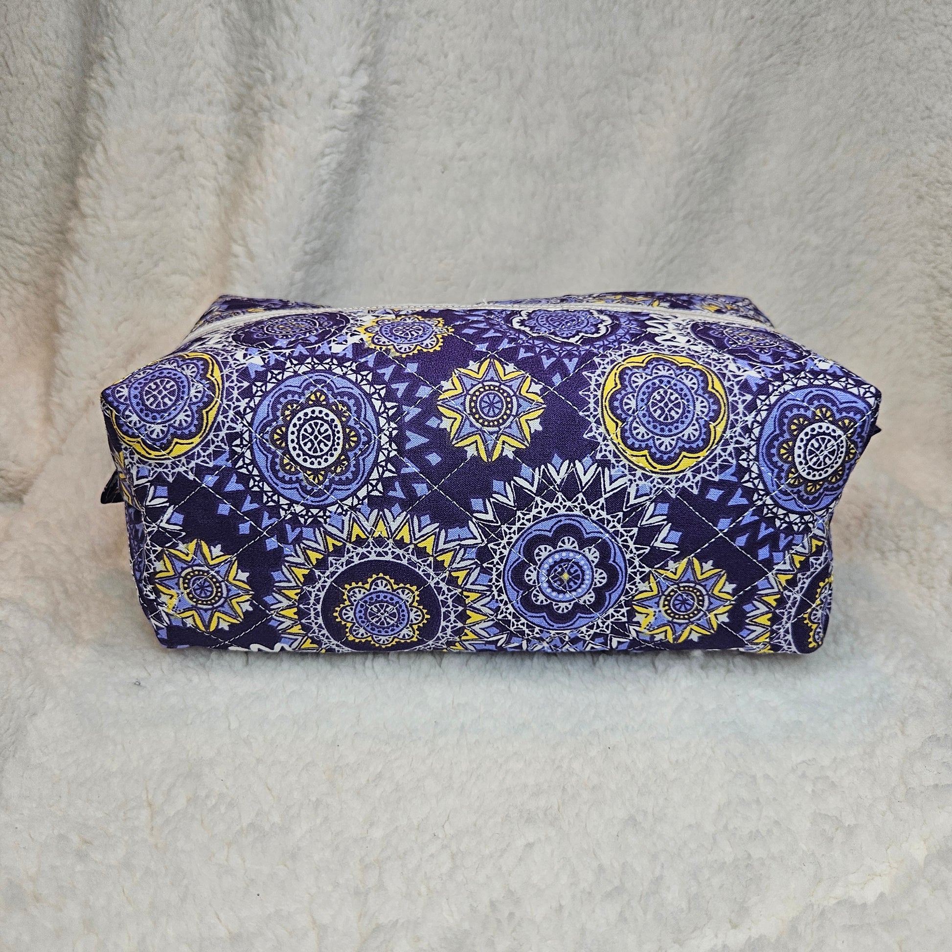 Purple and yellow patterned fabric on a white textured background
