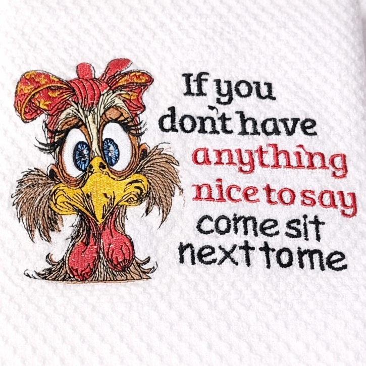 White towel with cartoon chicken and humorous text on a white background