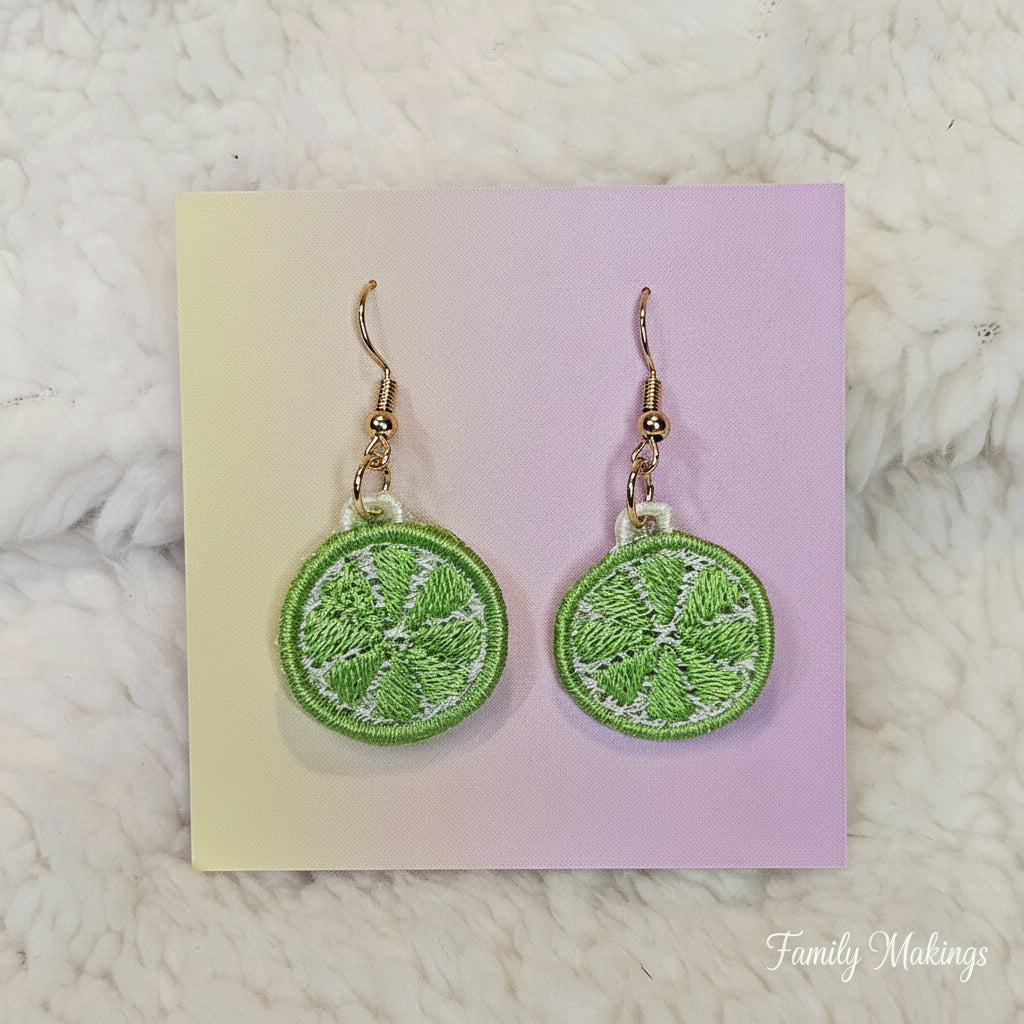 Embroidered Lime slice earrings with gold posts on a card