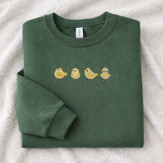 Folded military green sweatshirt with yellow chick design on a white background