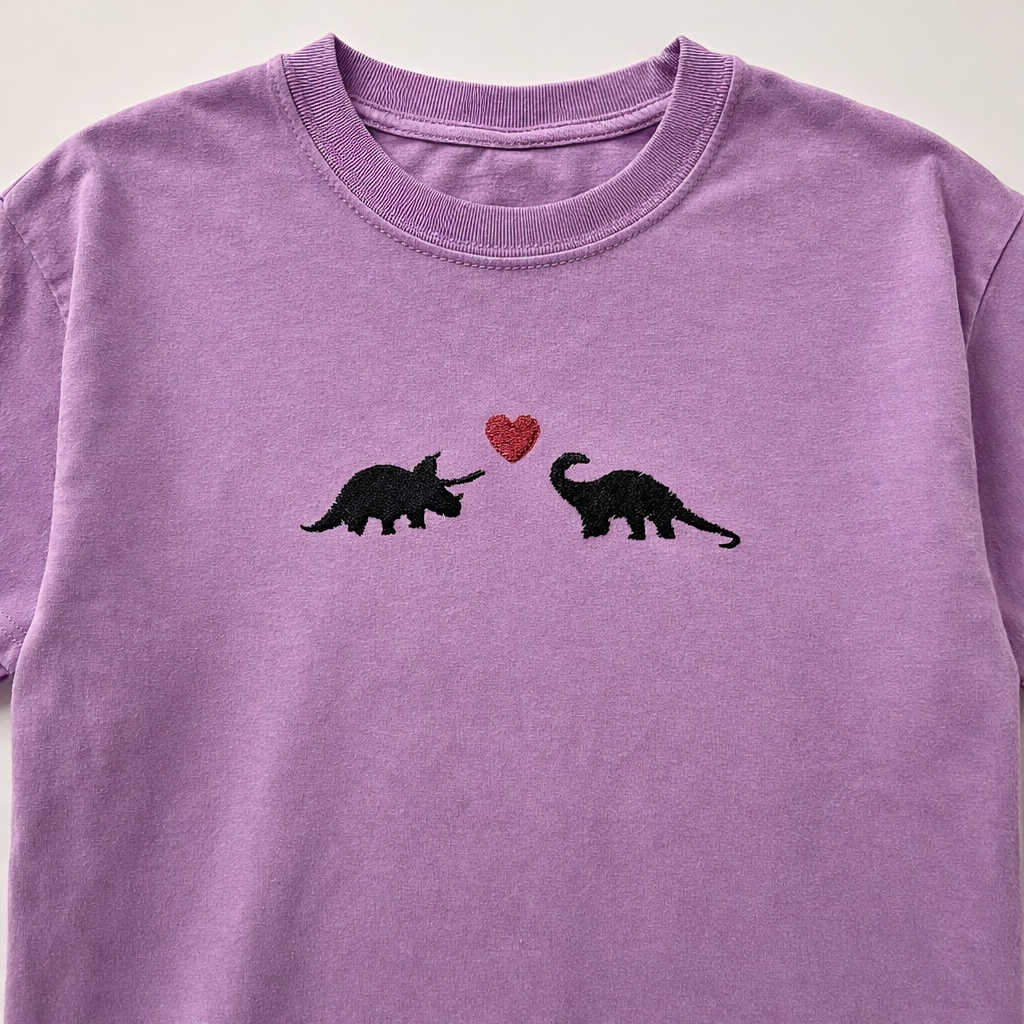 Orchid t-shirt with black dinosaur graphics and a red heart on a plain background
