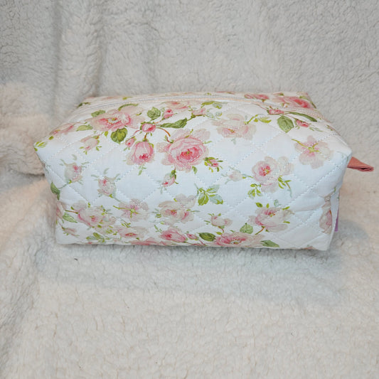 Floral-patterned quilted pouch on a textured surface