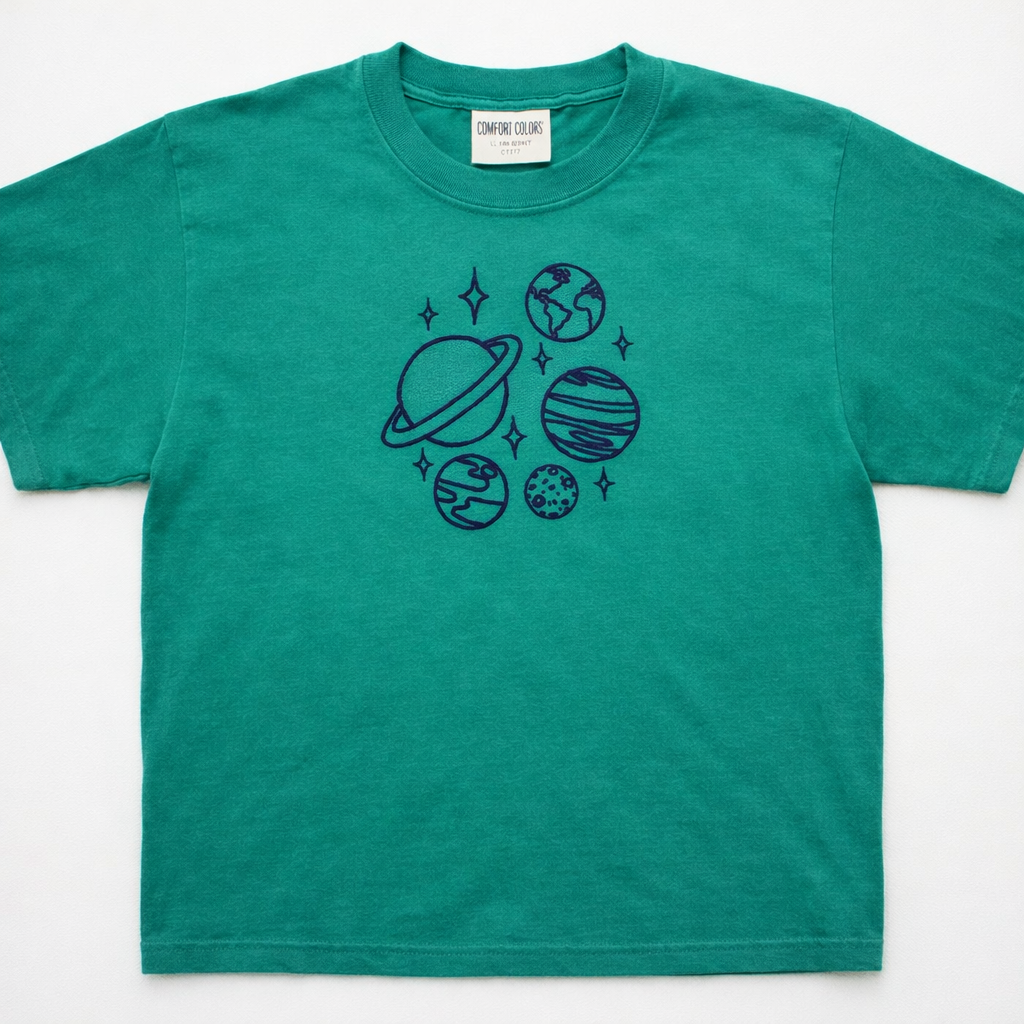 Emerald t-shirt with space-themed design on a white background