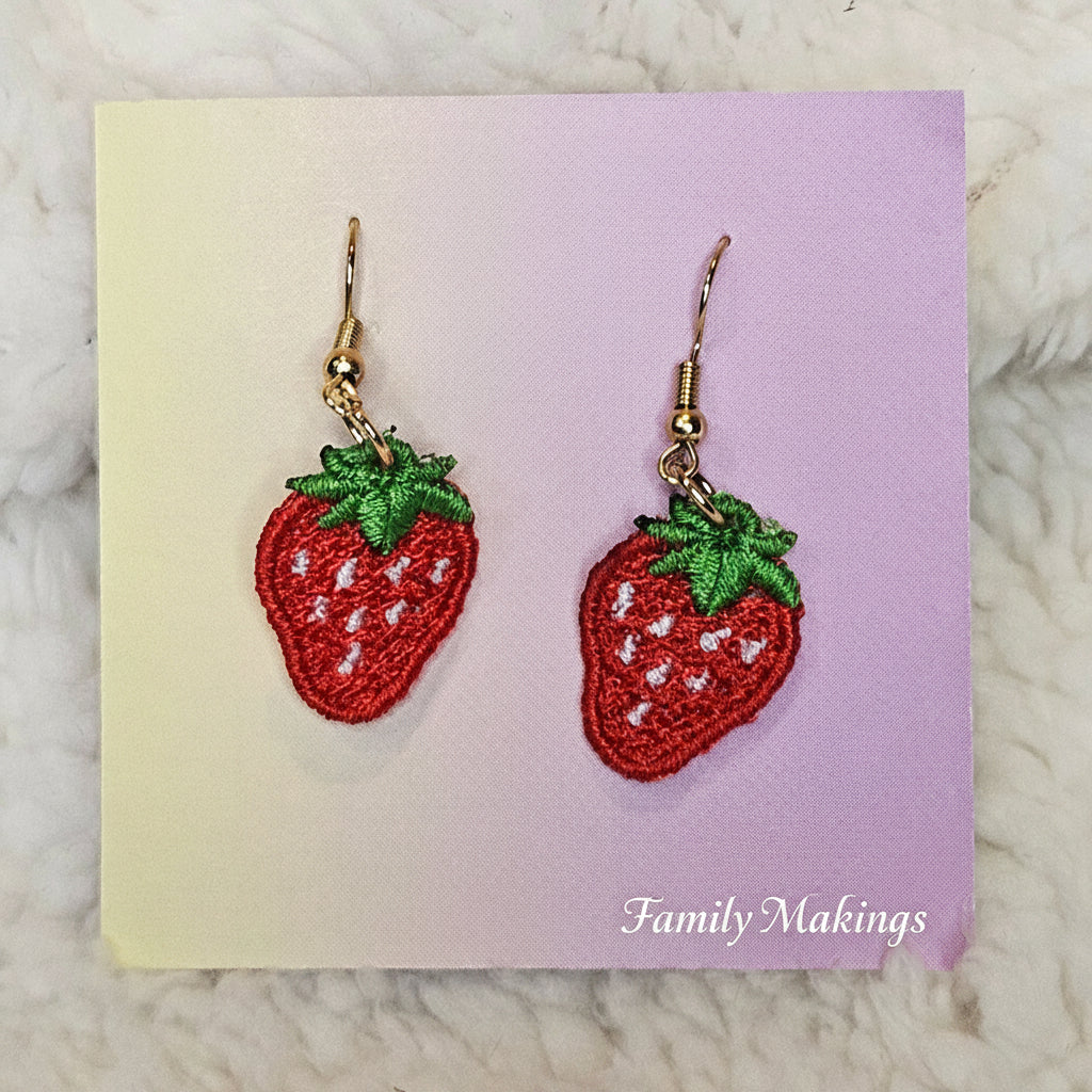 Strawberry embroidered earrings with gold posts on a card
