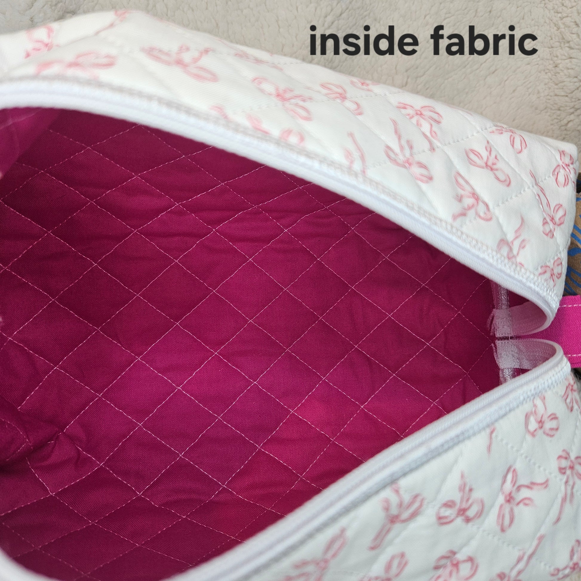 Close-up of quilted fabric with bow pattern on a pink background