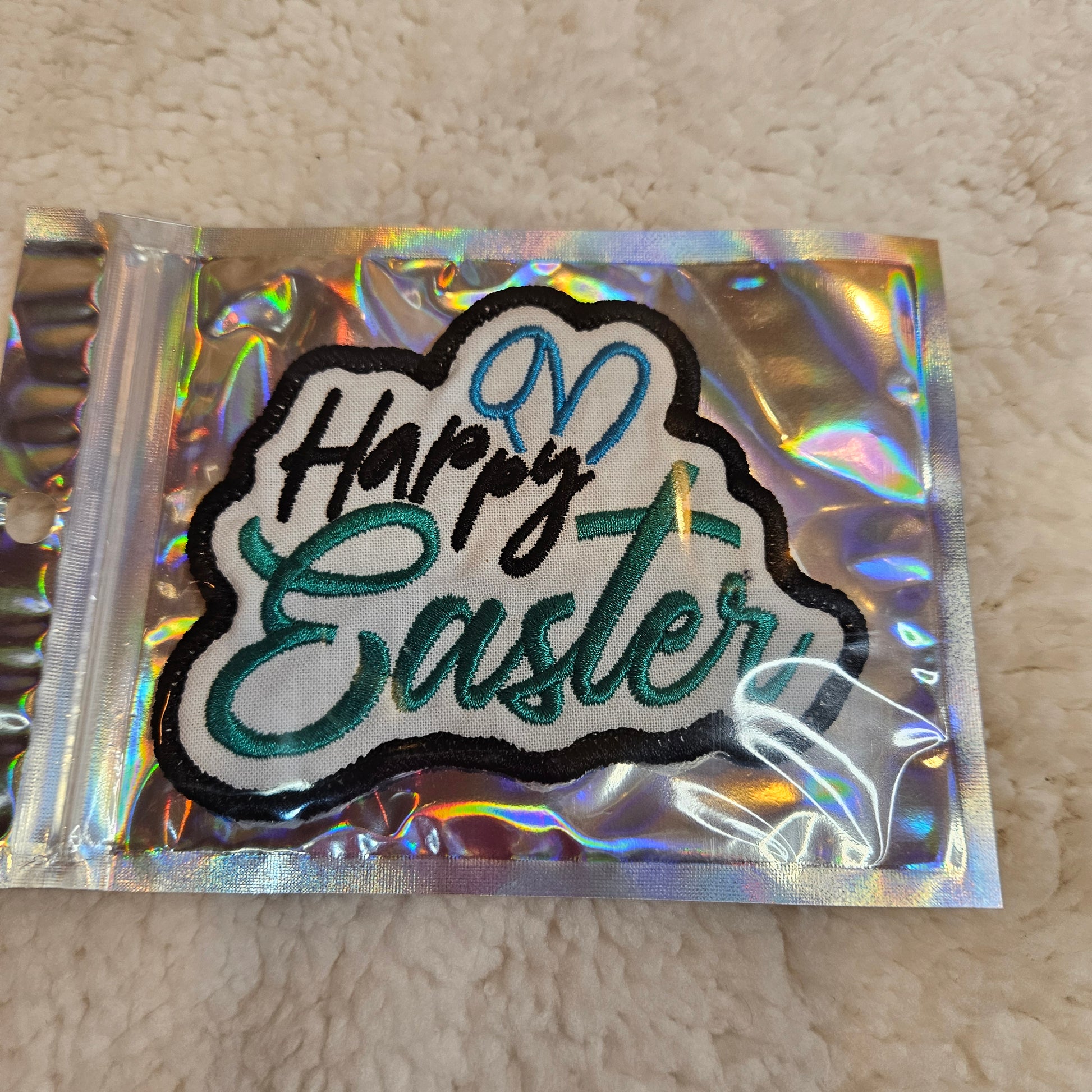 Embroidered patch with 'Happy Easter' text on a reflective backing