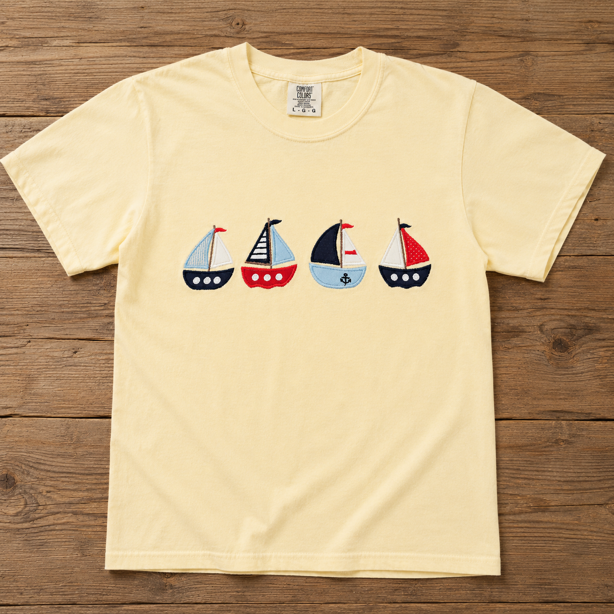 Butter t-shirt with sailboat design on a wooden surface