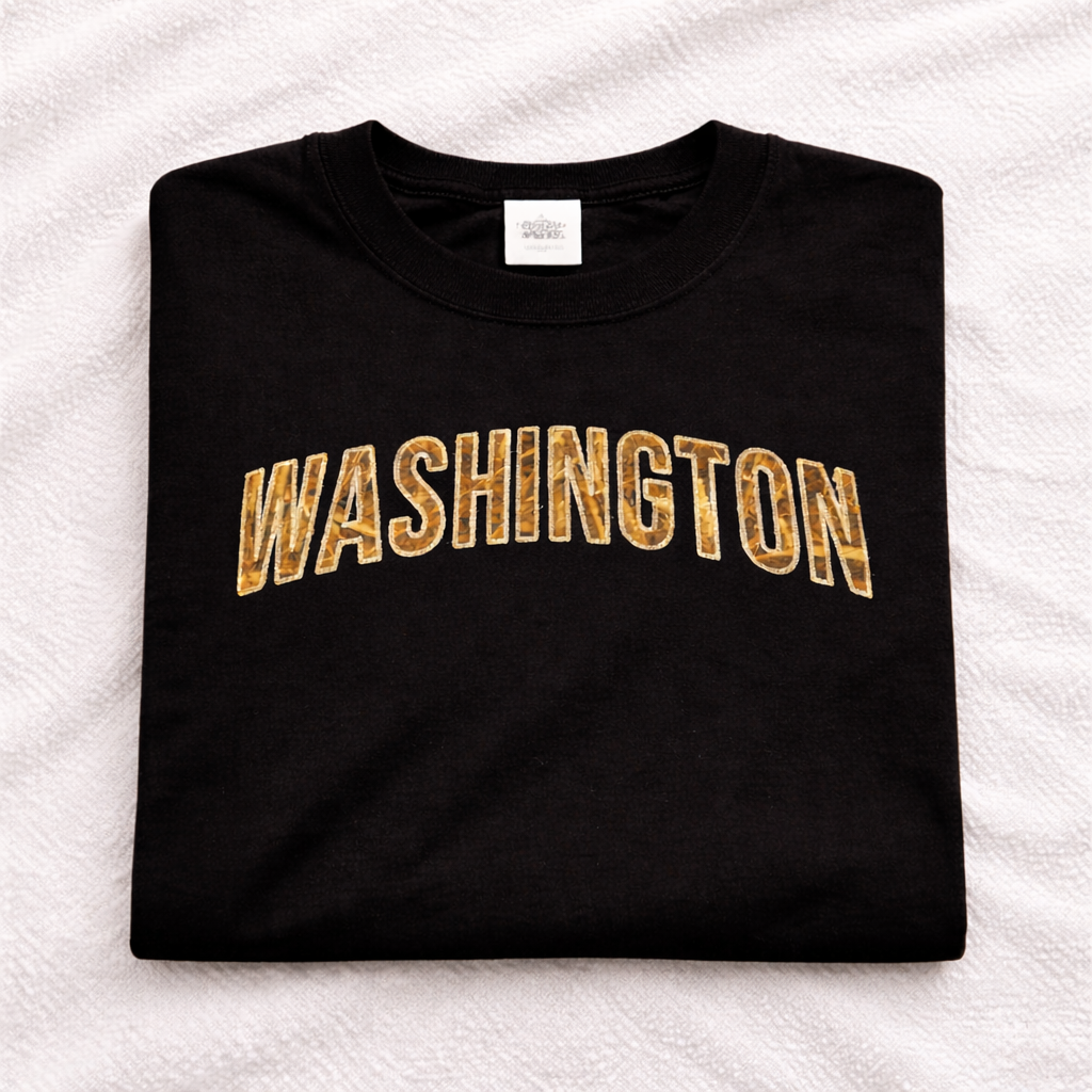 Black t-shirt with applique 'WASHINGTON' embroidered in beige on a white textured background
