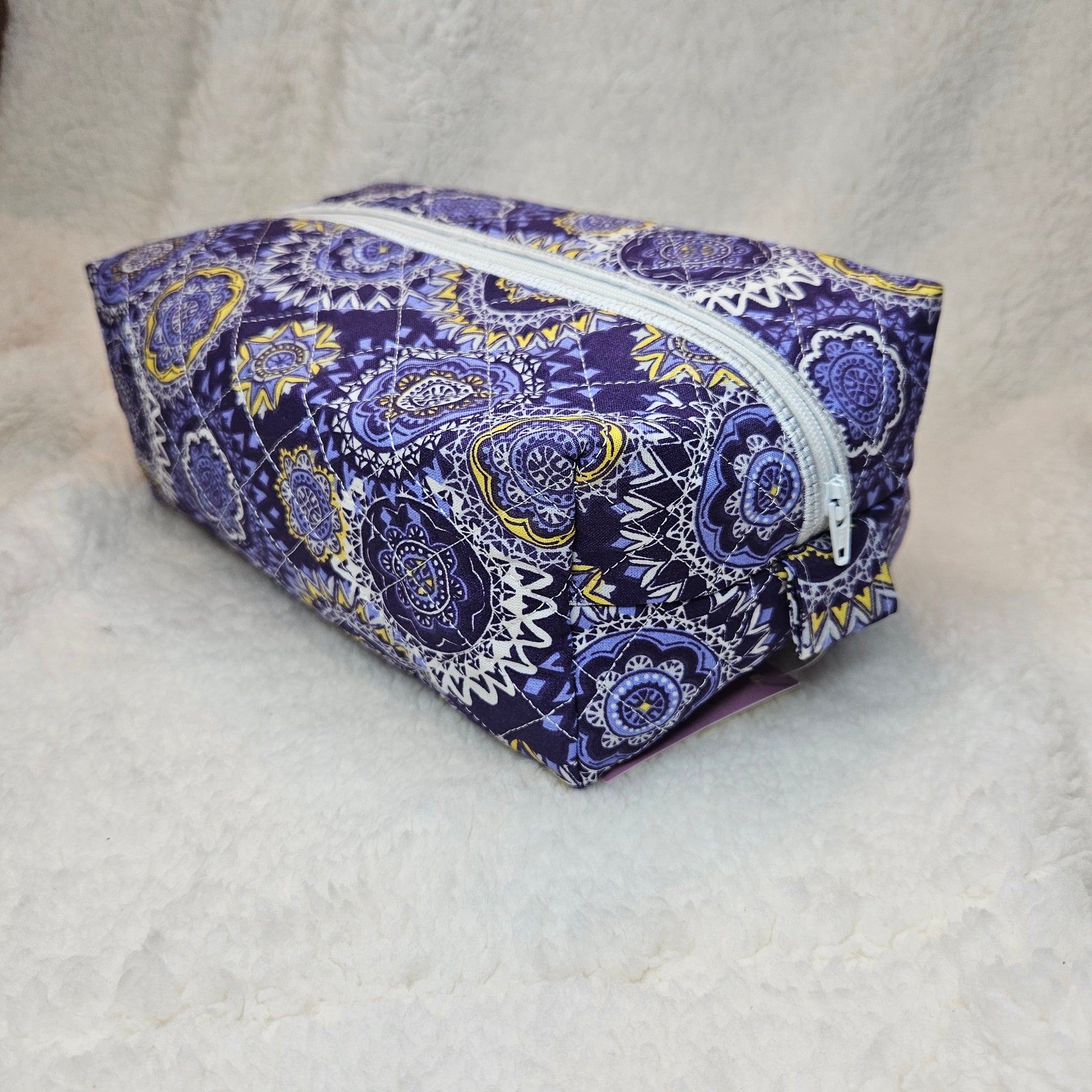 Purple patterned bag with a zipper on a light gray background