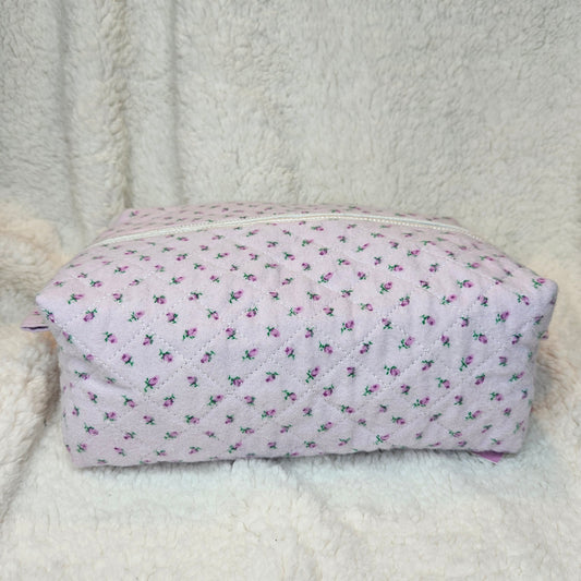 Floral-patterned pouch on a textured white surface