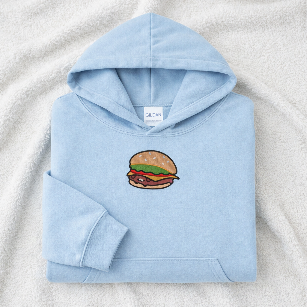 Light blue hoodie with a burger design on a textured surface