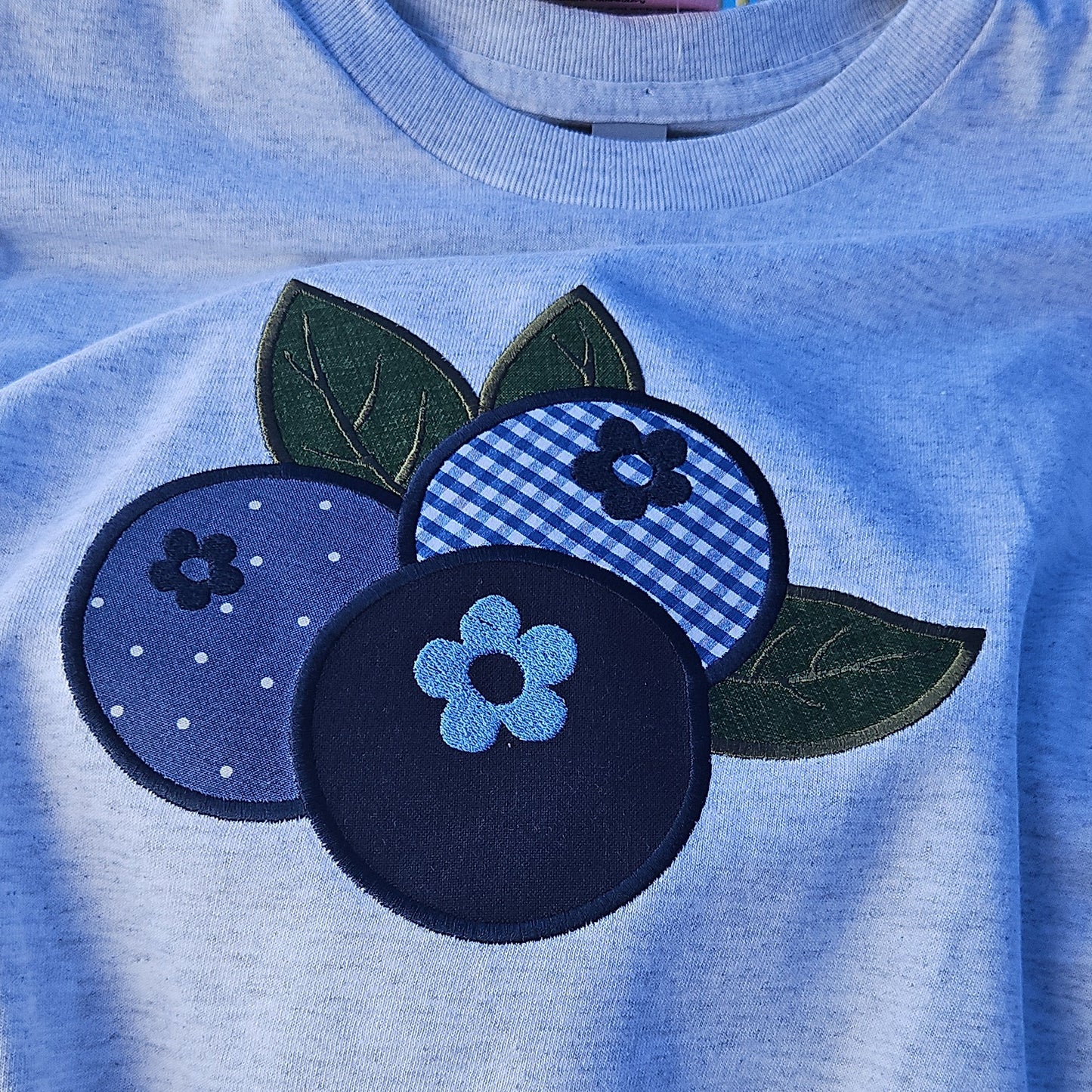 Blue fabric with a blueberry design on a hanger against a blue background