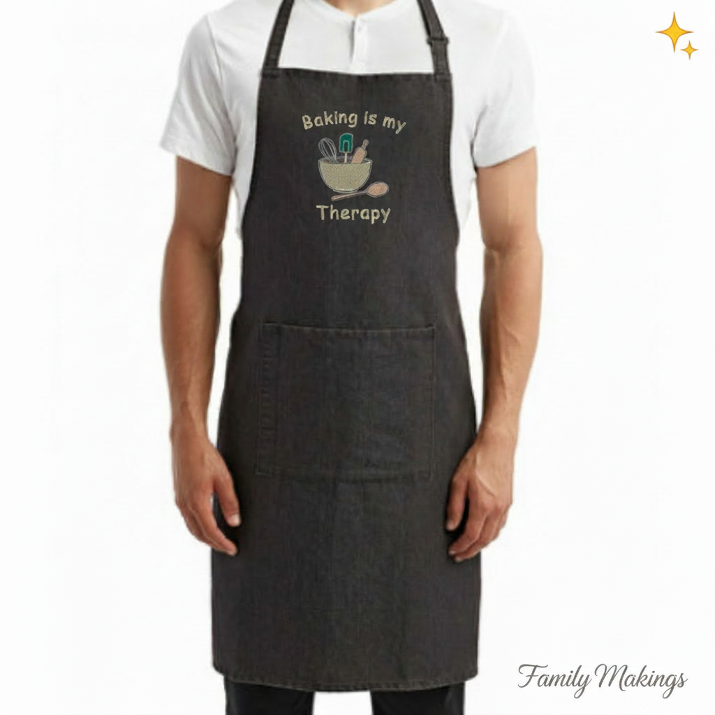 Person wearing a black denim apron with 'Baking is my Therapy' text and graphics on a white background