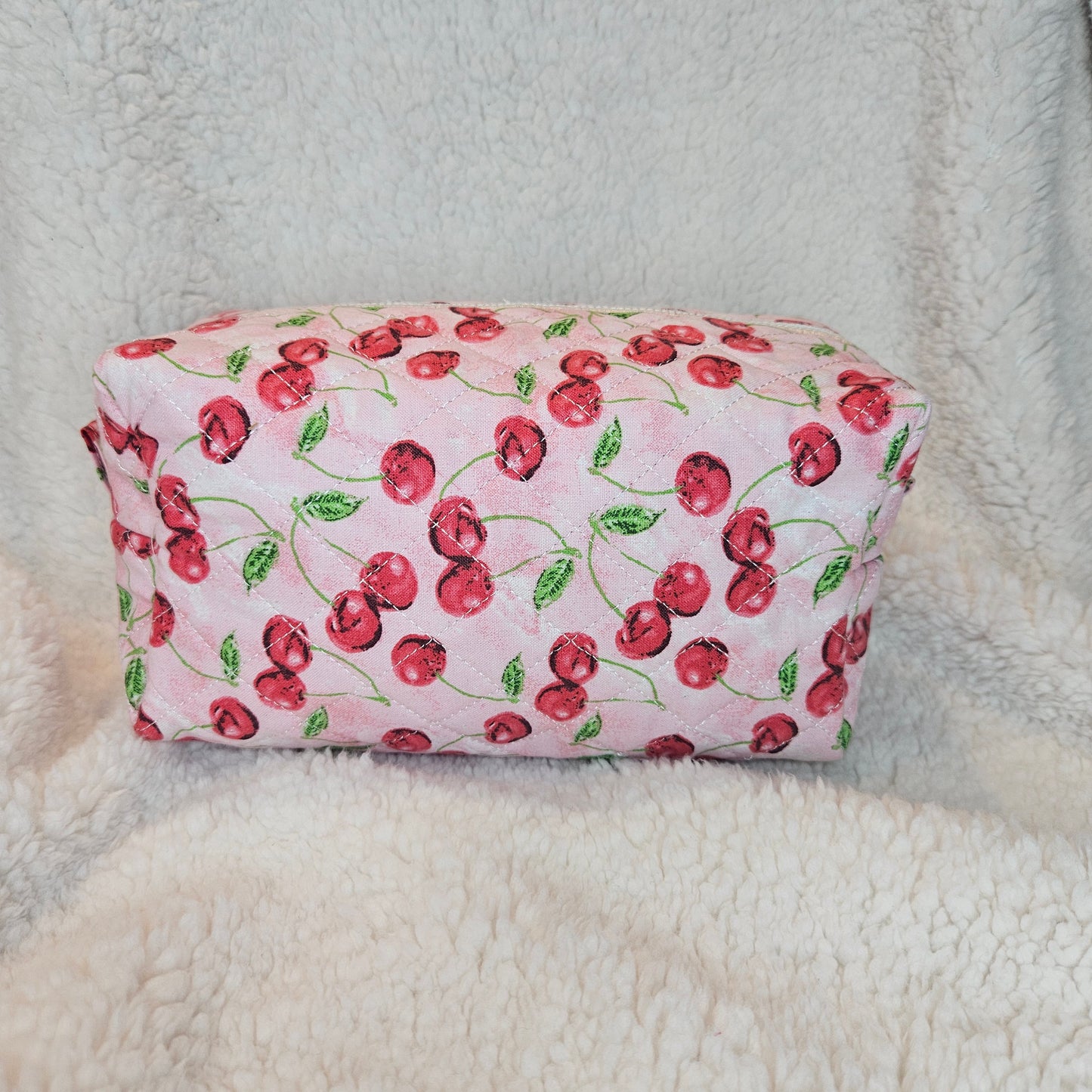 Boxy bag with cherry pattern on a textured surface