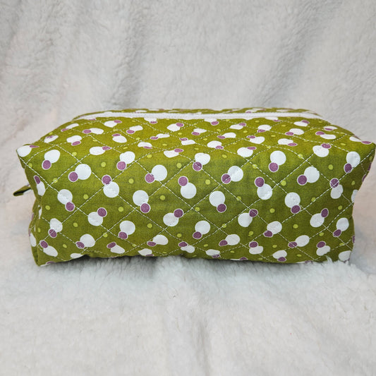 Green bag with white and purple polka dot pattern on a gray background