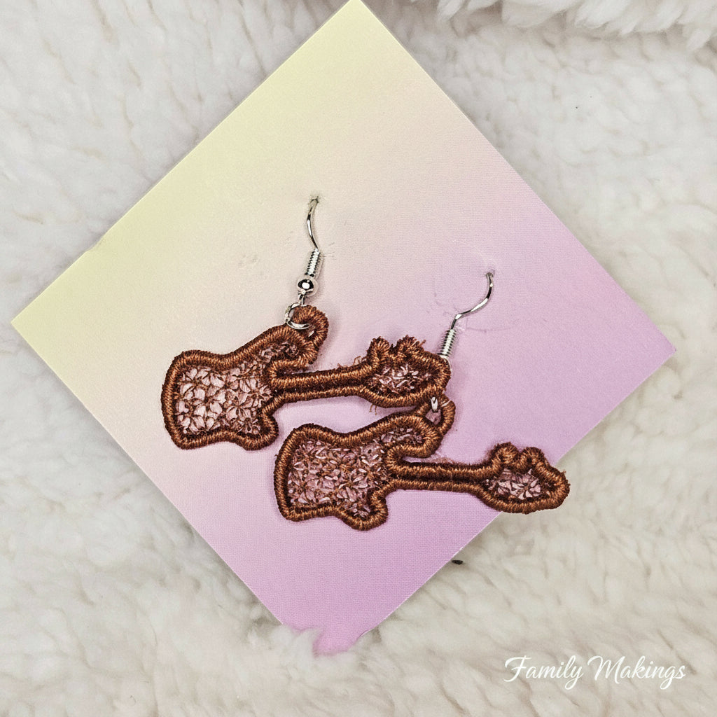 Embroidered brown guitar earrings on a card