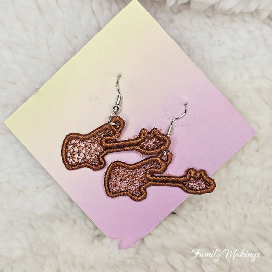 Embroidered brown guitar earrings on a card