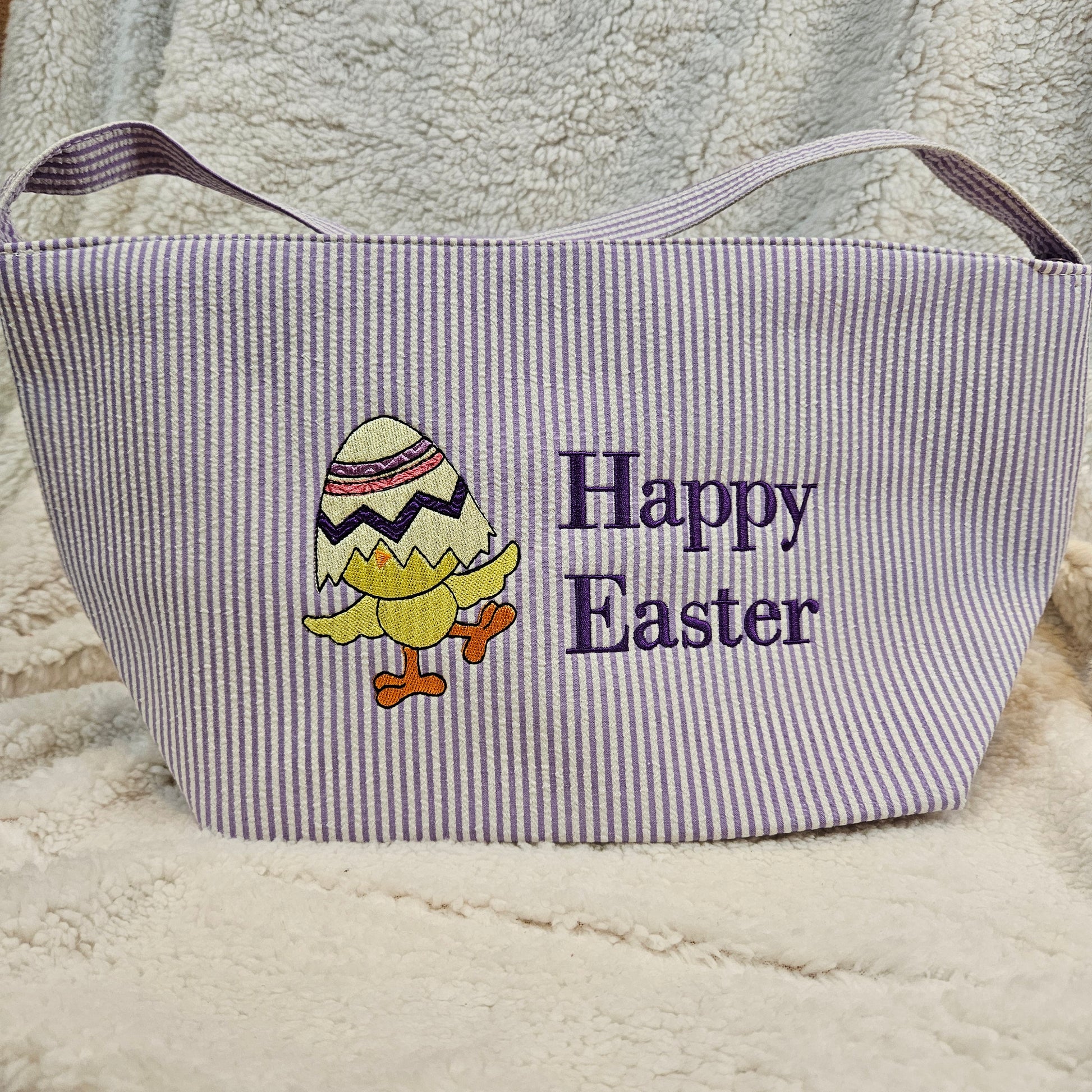 Purple striped bag with 'Happy Easter' text and embroidered egg design on a textured surface