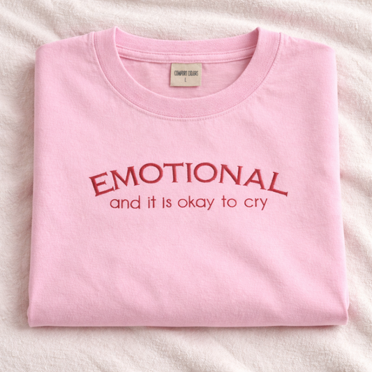 Folded blossom t-shirt with 'EMOTIONAL and it is okay to cry' embroidered text on a white background