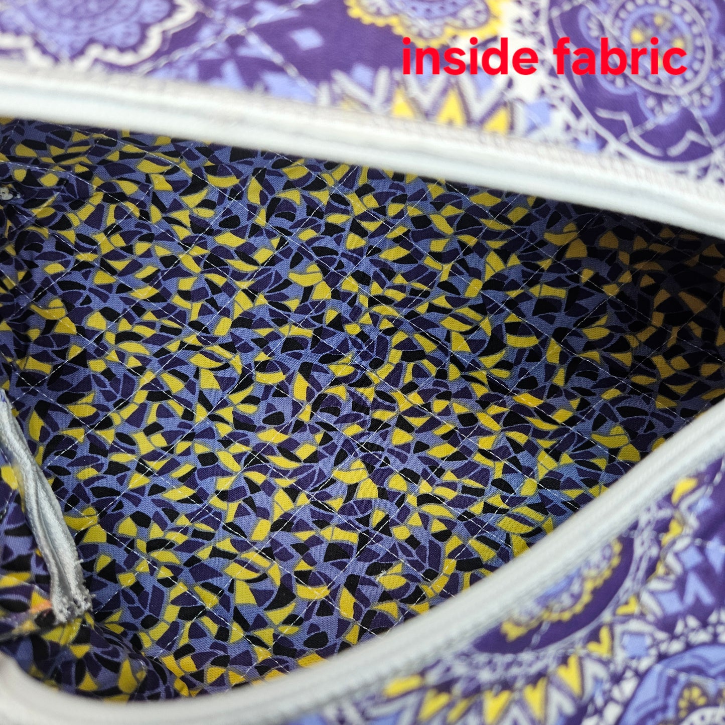 Close-up of a fabric with a geometric pattern inside a larger fabric with a different design.