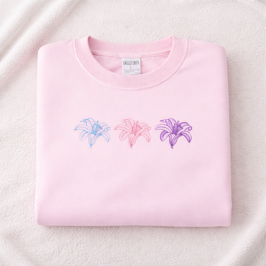 Light pink sweatshirt with embroidered lily designs on a light pink background