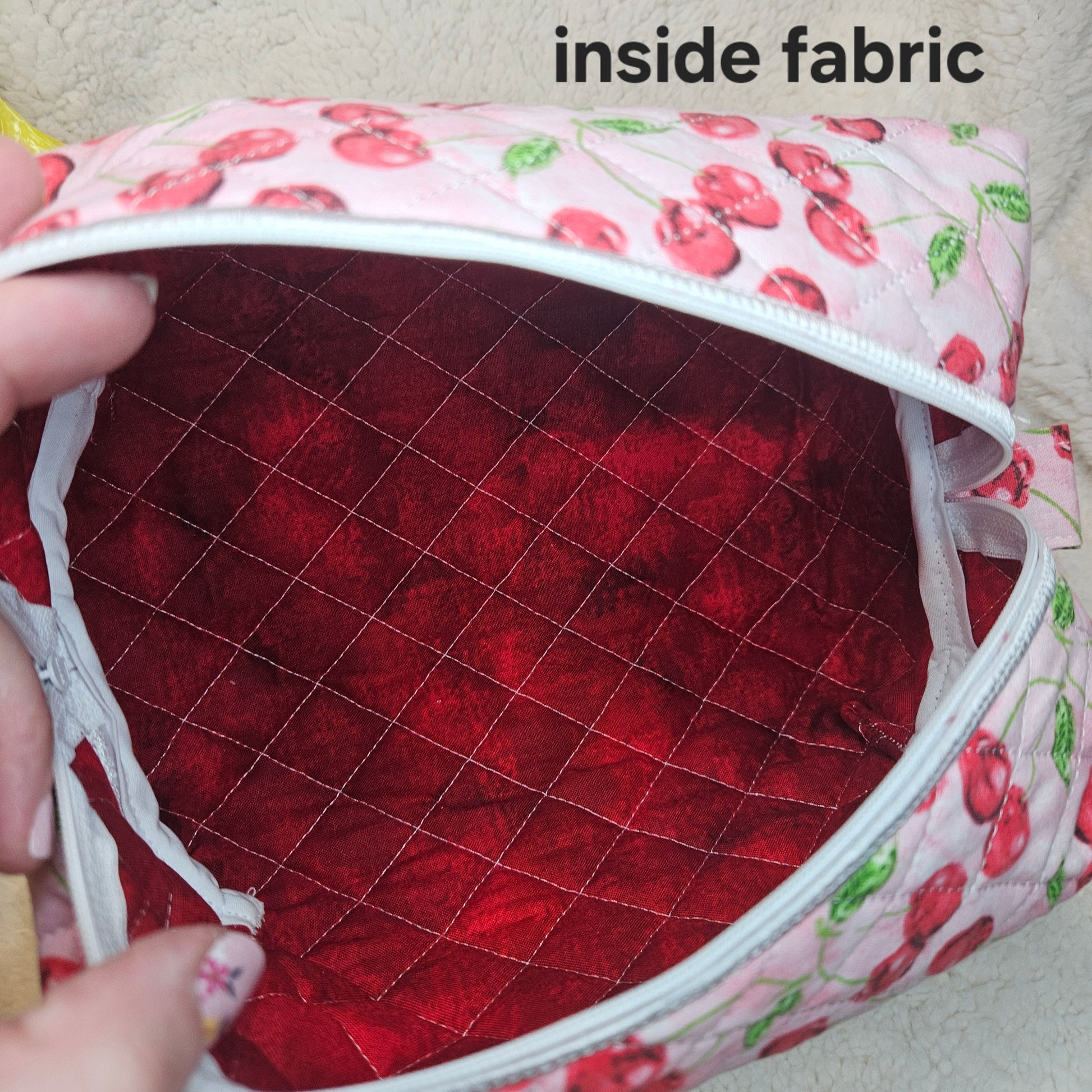 Close-up of a fabric product with red interior and pink exterior featuring cherry patterns.