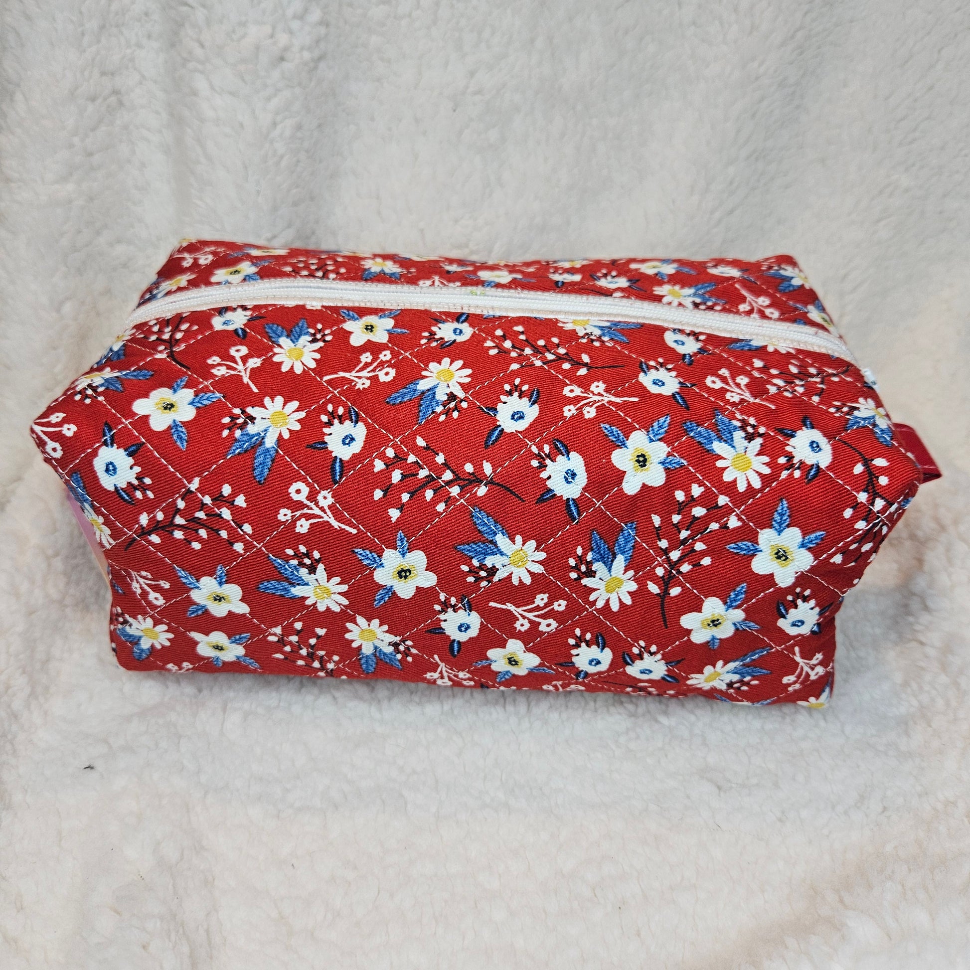 Red floral-patterned pouch on a textured gray background