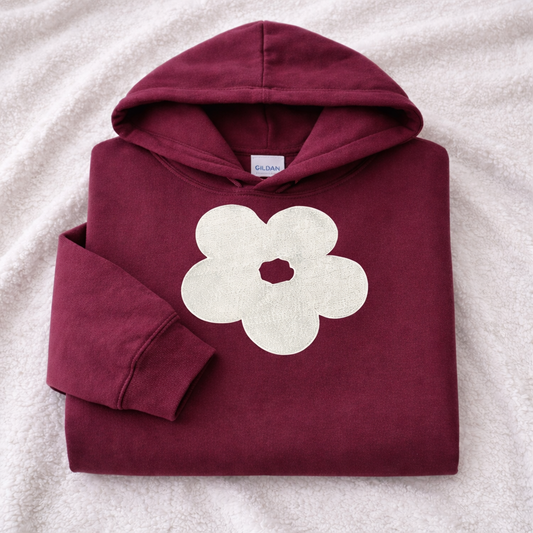Maroon hoodie with a white flower design on a white background