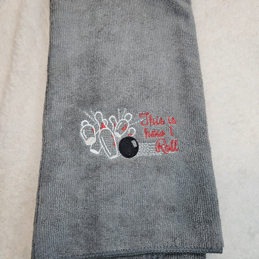 Gray towel with bowling design and text on a light background