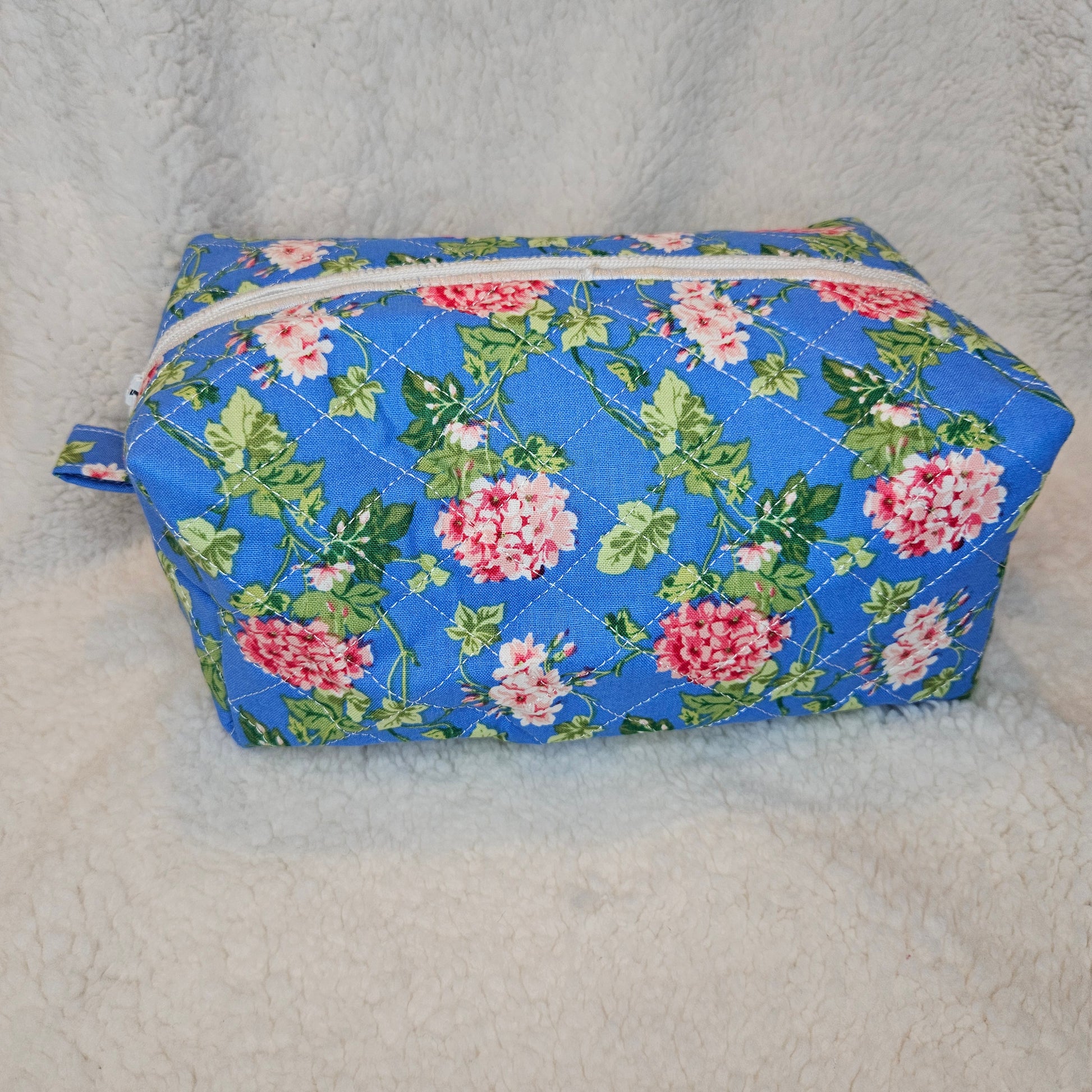 Floral-patterned fabric pouch with a zipper on a gray background
