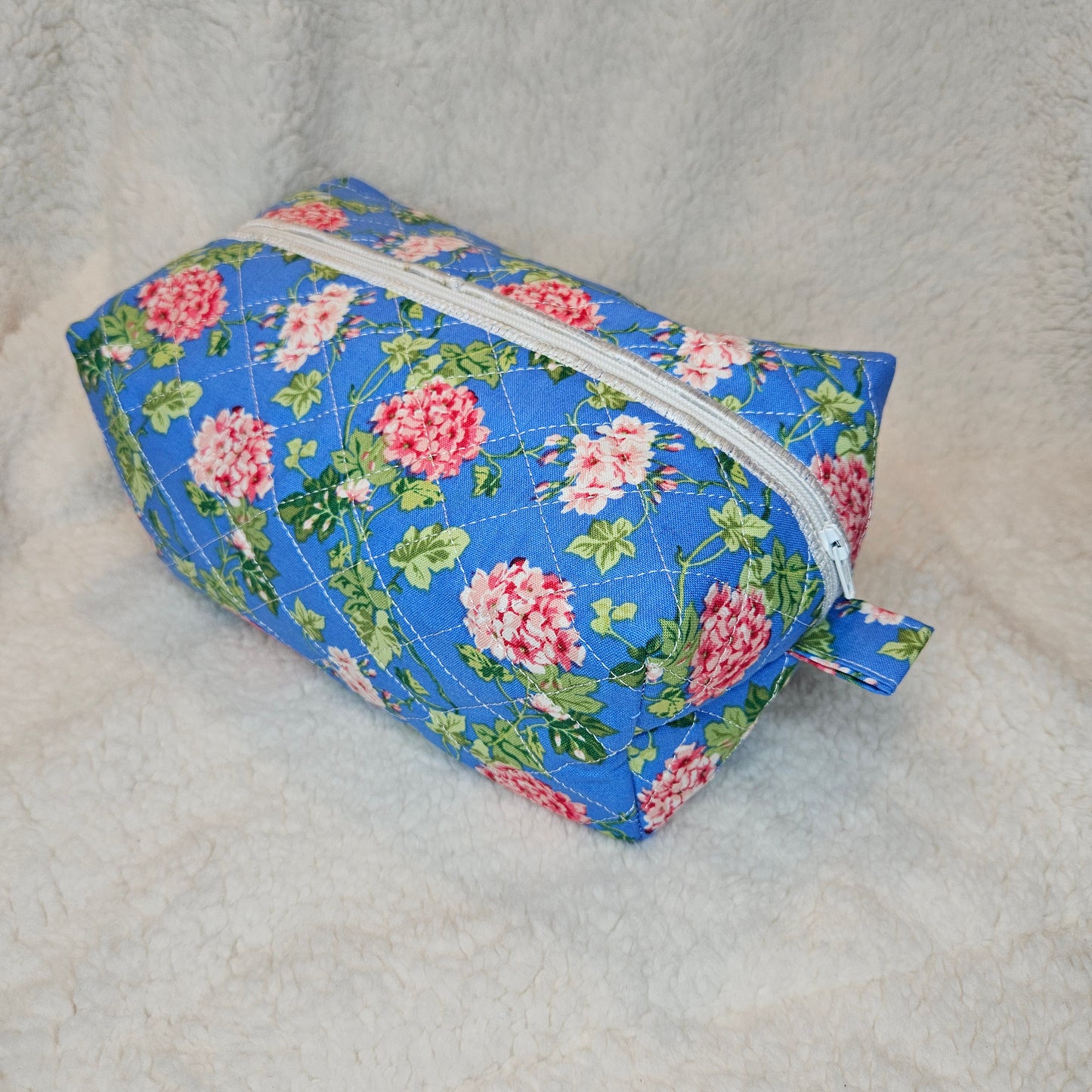 Floral-patterned zipper pouch on a textured surface