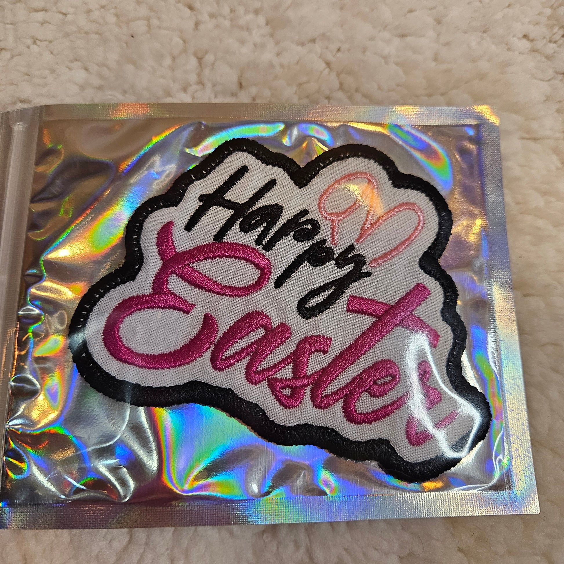 Embroidered patch with 'Happy Easter' text on a reflective card