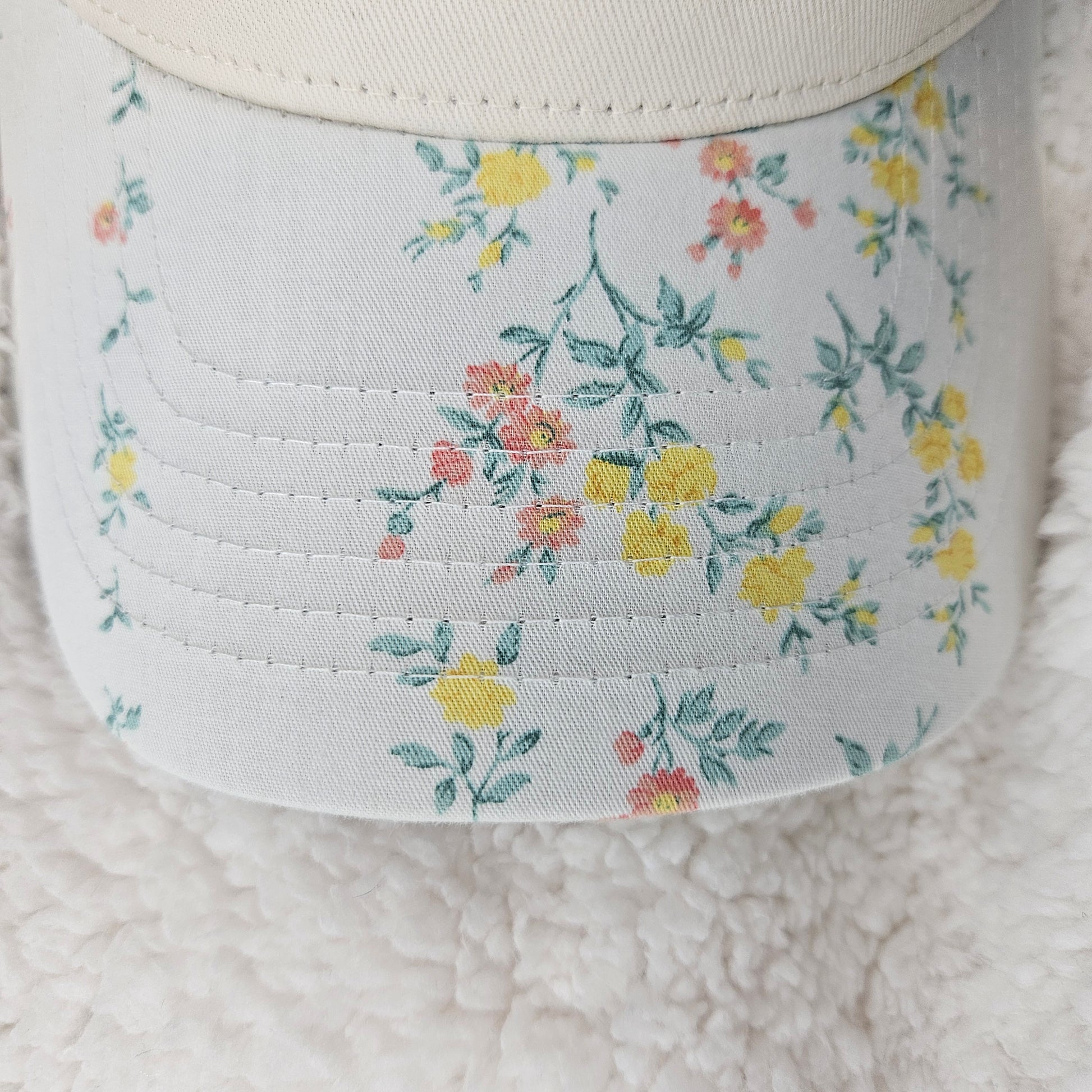 Floral-patterned bill of hat on a light gray background