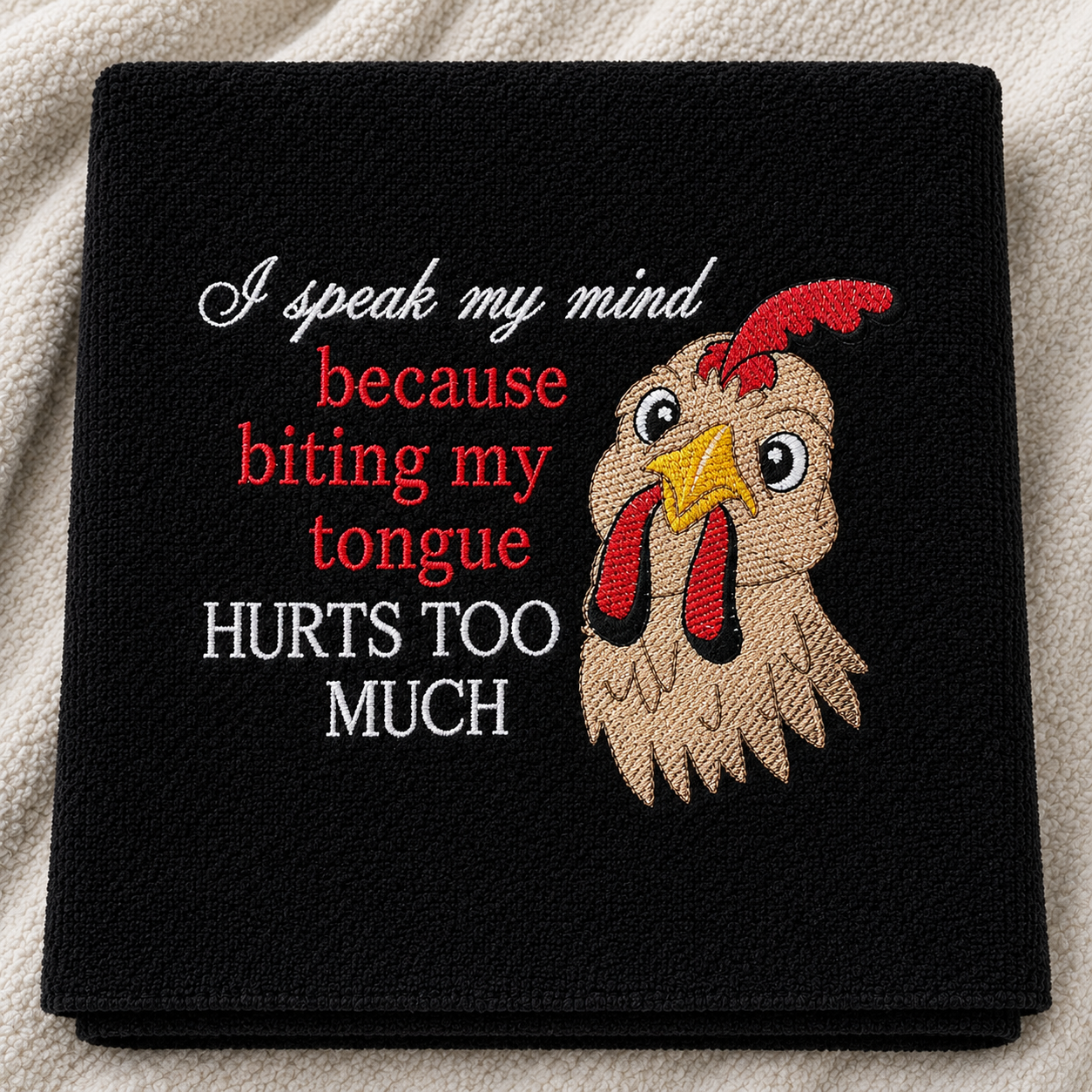Black towel with a rooster illustration and humorous text on a white background