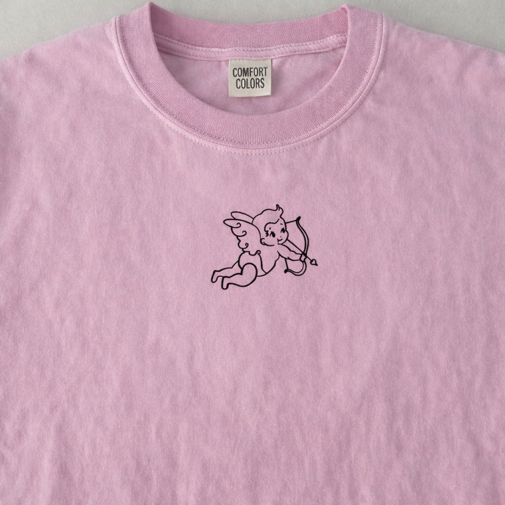 Blossom t-shirt with a small black design of a winged figure holding an arrow on a gray background.