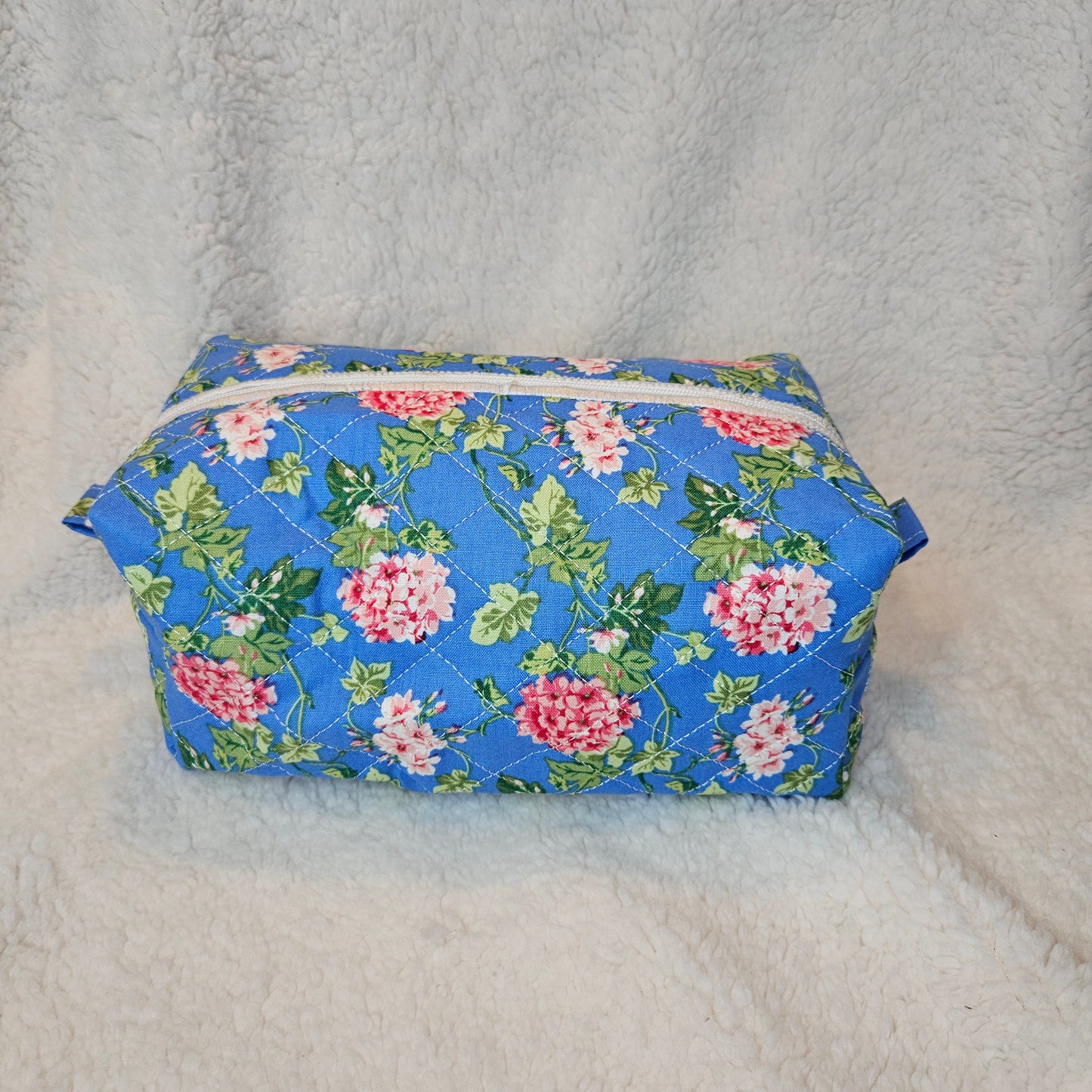 Floral-patterned bag with a zipper on a textured gray background