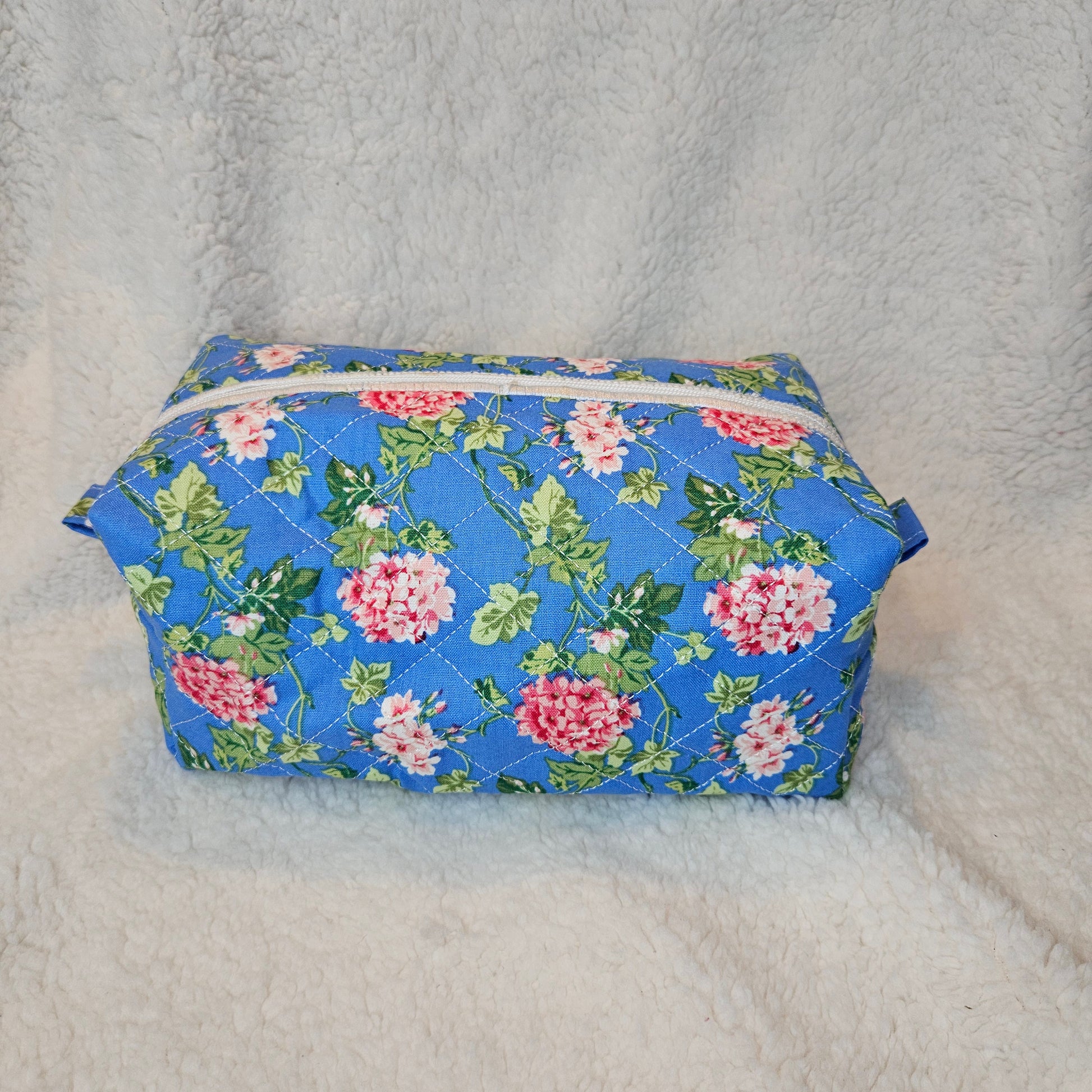 Floral-patterned bag with a zipper on a textured gray background