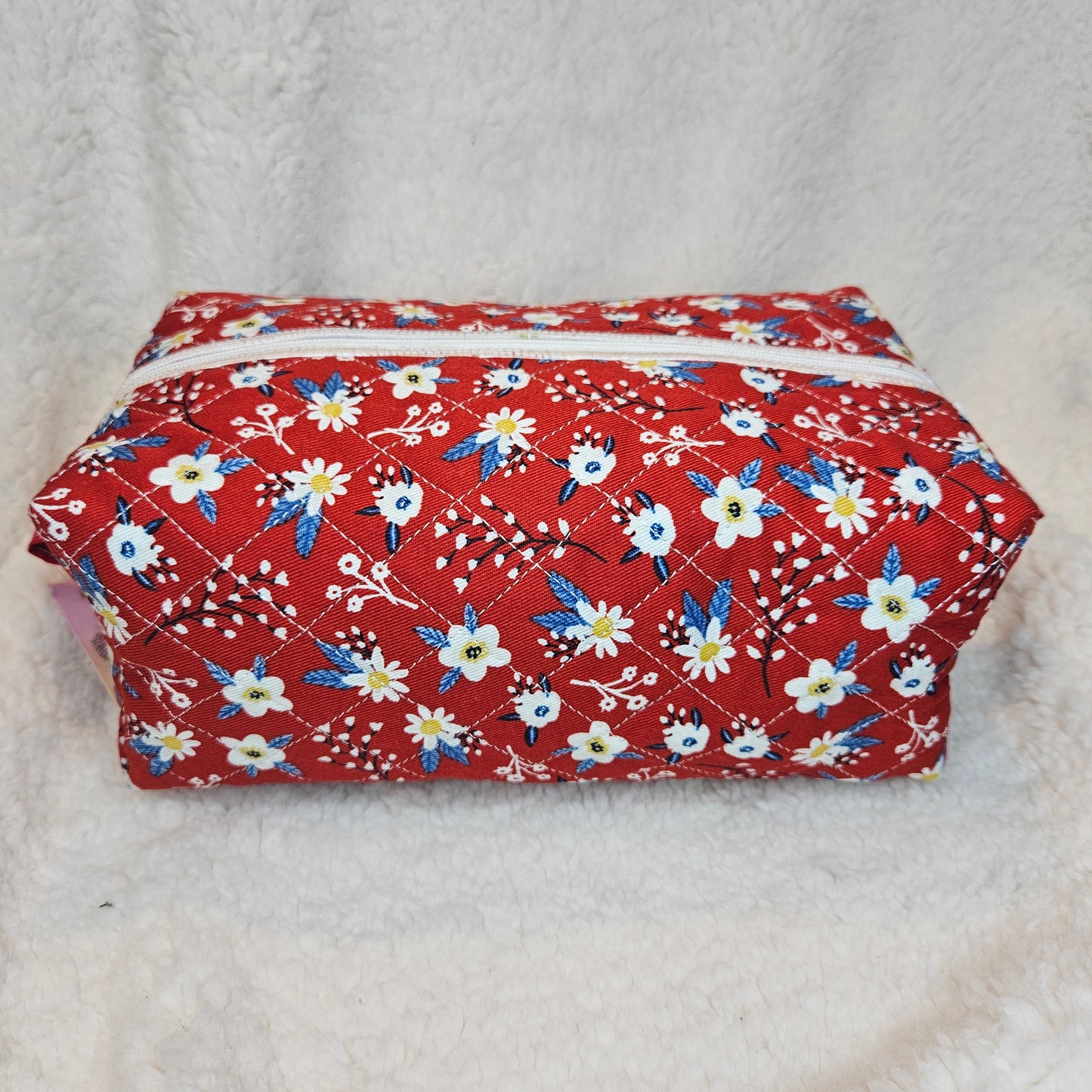 Floral-patterned pouch on a textured white background
