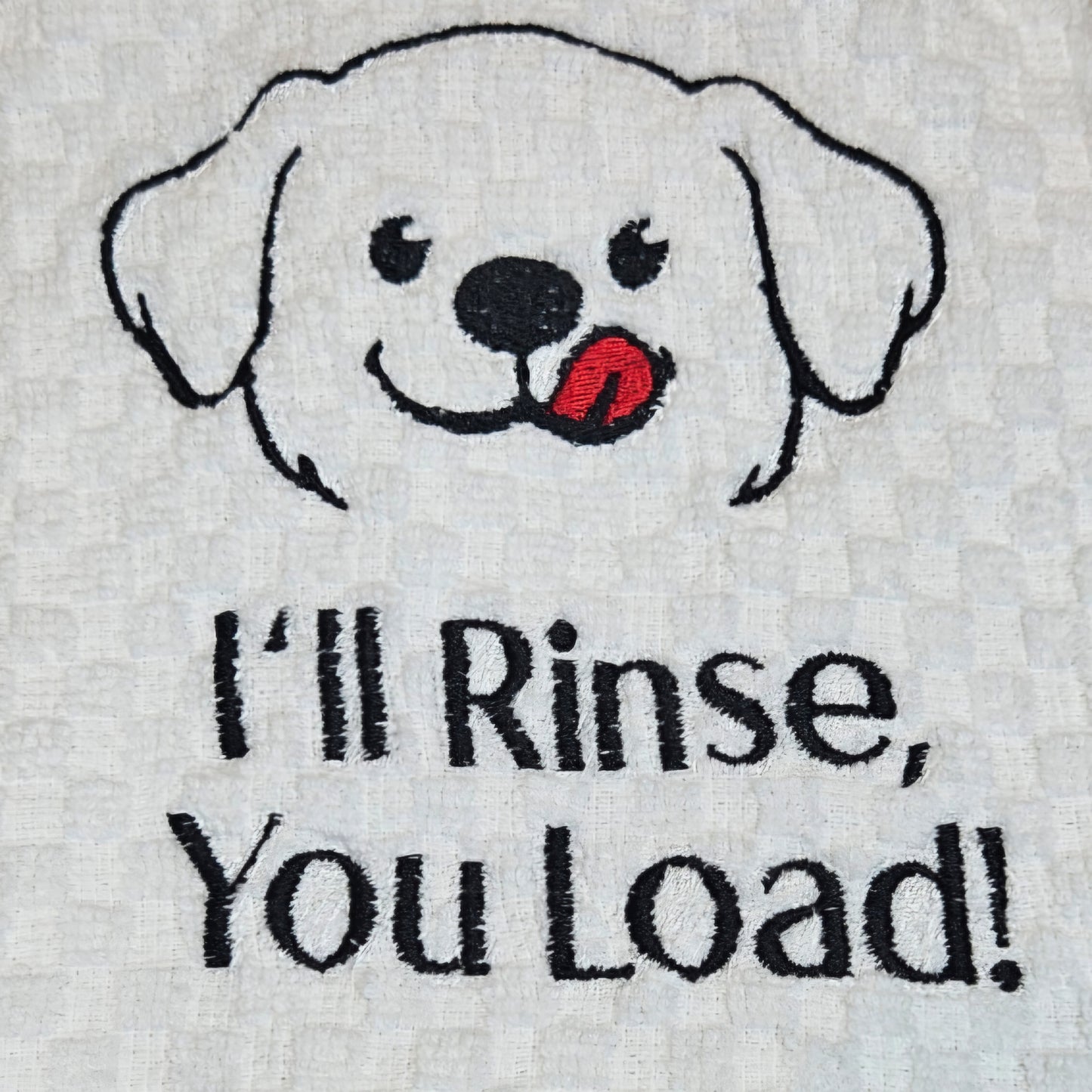 Embroidered towel with a dog face and text 'I'll Rinse, You Load!' on a white background.
